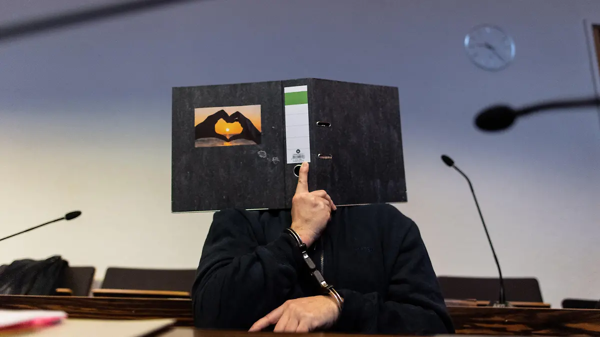 ARCHIV - 08.05.2019, Baden-Württemberg, Freiburg: Der 58-jährige Angeklagte sitzt im Gerichtssaal im Landgericht und hält einen Aktenordner mit einem Herz aus zwei Händen vor sein Gesicht. Ihm werden die Entziehung Minderjähriger und schwerer sexueller Missbrauch von Kindern vorgeworfen. Der Mann aus Blomberg in Nordrhein-Westfalen soll im Mai 2013 mit der damals 13-Jährigen Maria ins Ausland geflüchtet sein, ohne dass deren Eltern davon wussten. Foto: Patrick Seeger/dpa +++ dpa-Bildfunk +++