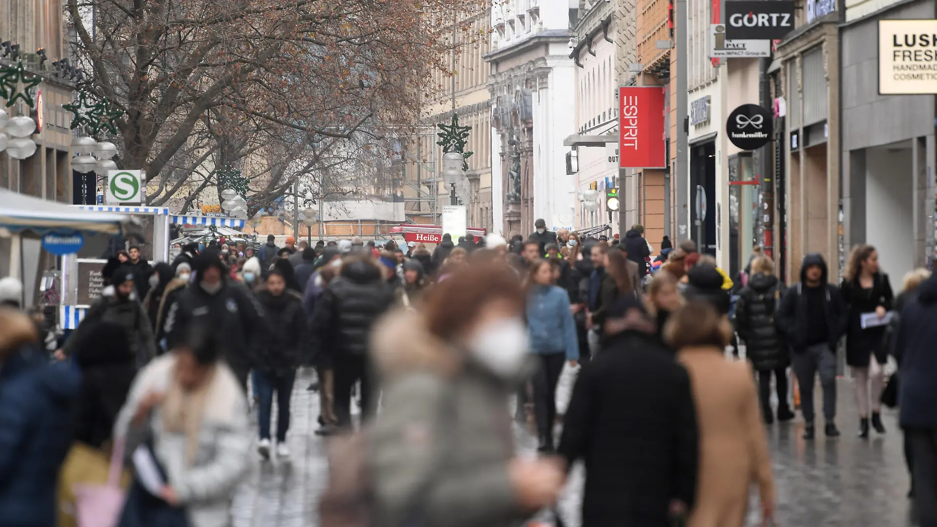 Menschen gehen durch die Kaufingerstraße, eine Einkaufstraße in der Münchner Innenstadt.