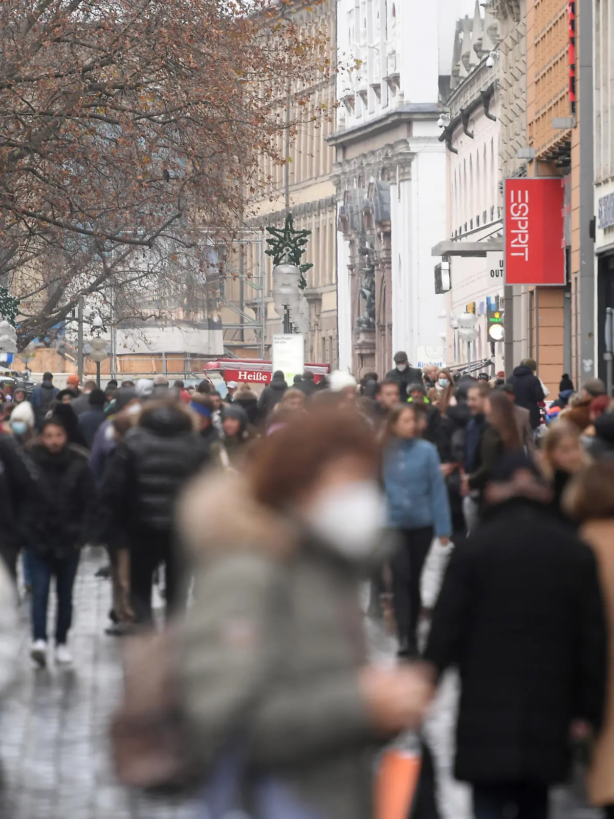 Menschen gehen durch die Kaufingerstraße, eine Einkaufstraße in der Münchner Innenstadt.