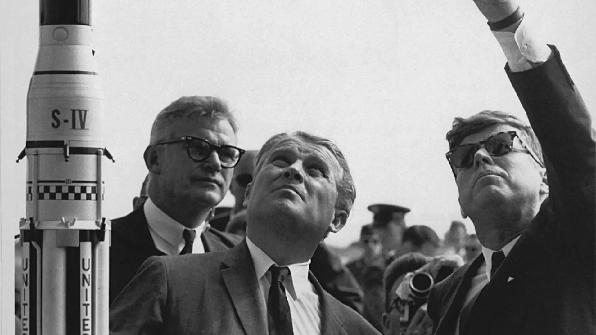 ARCHIV - 15.11.1963, USA, Cape Canaveral: Wernher von Braun (M), Raketenkonstrukteur aus Deutschland steht neben dem damaligen US-Präsidenten John F. Kennedy und erklärt ihm das Saturn-Startsystem. Foto: -/Nasa Headquarters HO/dpa - ACHTUNG: Nur zur redaktionellen Verwendung und nur mit vollständiger Nennung des vorstehenden Credits +++ dpa-Bildfunk +++