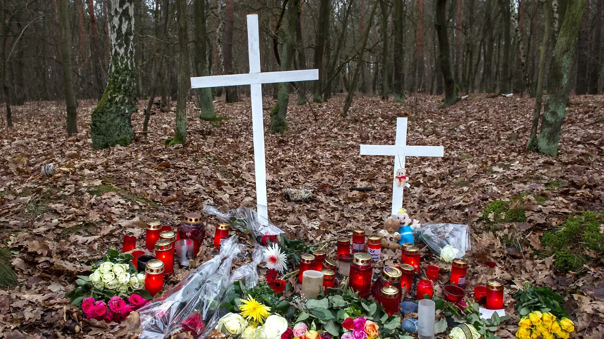 Kreuze, Blumen und Kerzen sind am 26.01.2015 in Berlin in einem Waldstück an der Bärenlauchstraße abgelegt worden. An dieser Stelle war eine Frau von Spaziergängern tot aufgefunden worden. Nach den bisherigen Ermittlungen wurde die schwangere Frau niedergestochen und dann noch lebend verbrannt. Die Polizei hat zwei Tatverdächtige festgenommen. Foto: Paul Zinken/dpa +++(c) dpa - Bildfunk+++