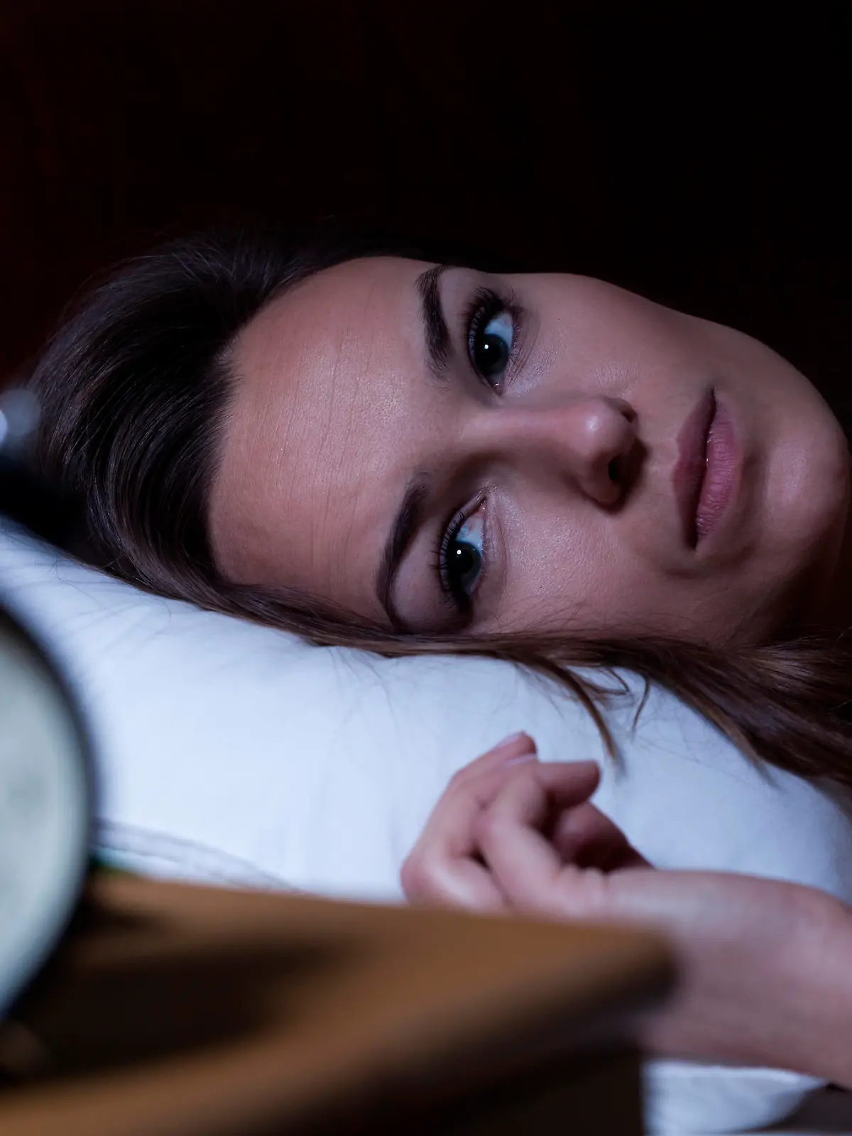 Woman lying in bed suffering from insomnia