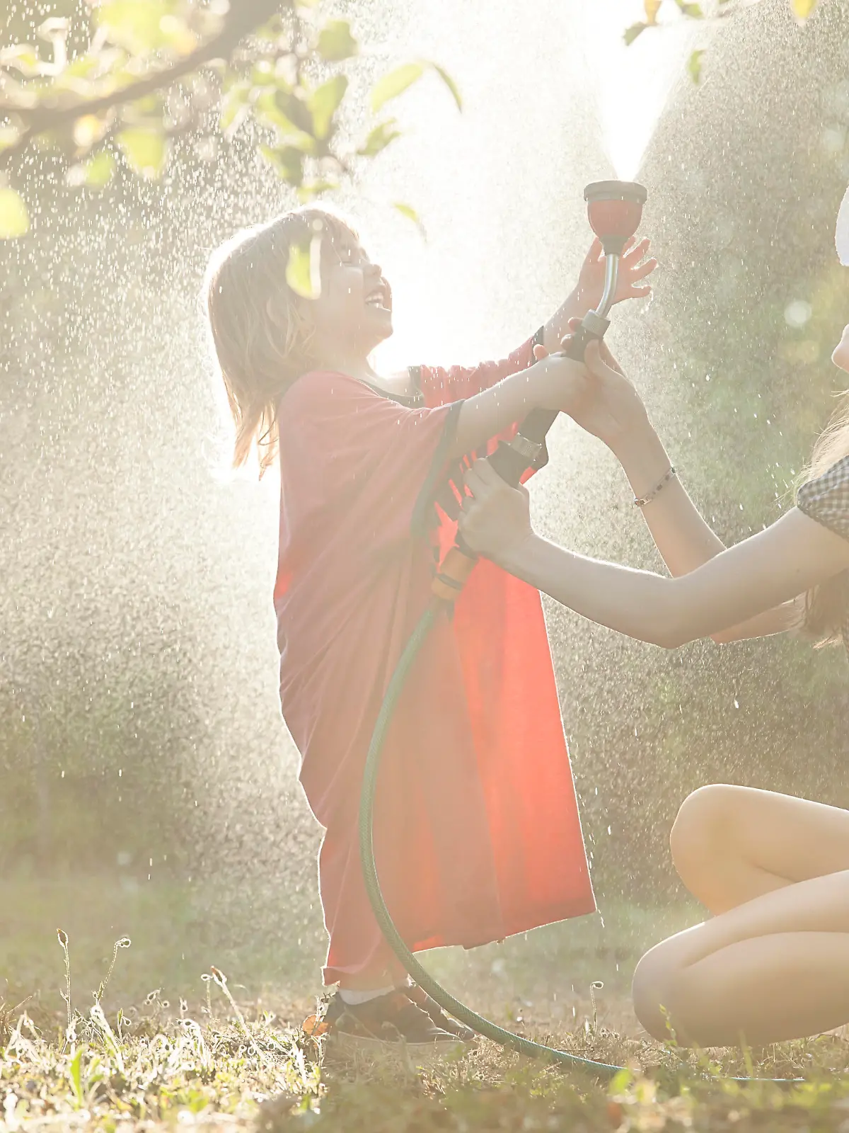 Mutter und Kind beim Wasserspaß im Garten.