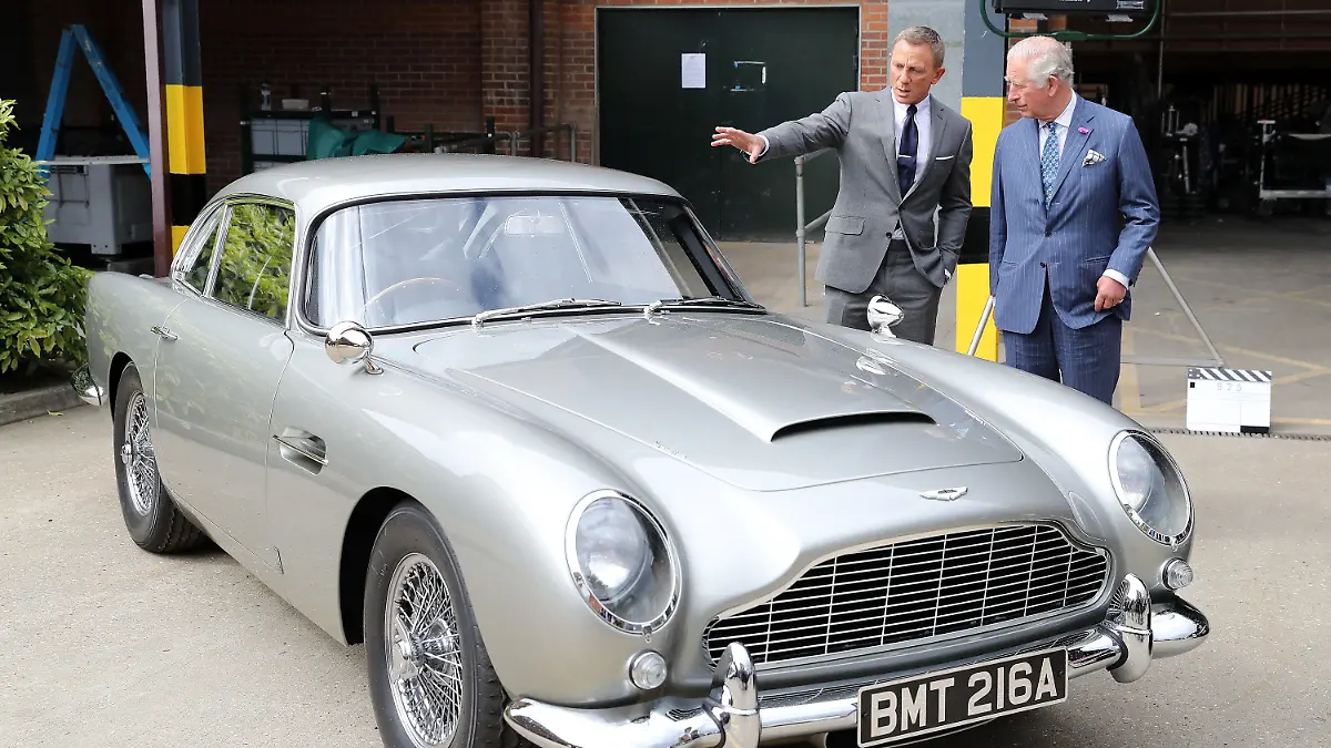 20.06.2019, Großbritannien, Iver Heath: Charles (r), britischer Prinz von Wales, steht mit dem Schauspieler Daniel Craig bei einem Besuch des Sets des 25. James-Bond-Films in den Pinewood Studios hinter dem Aston Martin DB5 Bond-Auto aus einem Bond-Film, während Craig spricht. Foto: Chris Jackson/PA Wire/dpa +++ dpa-Bildfunk +++