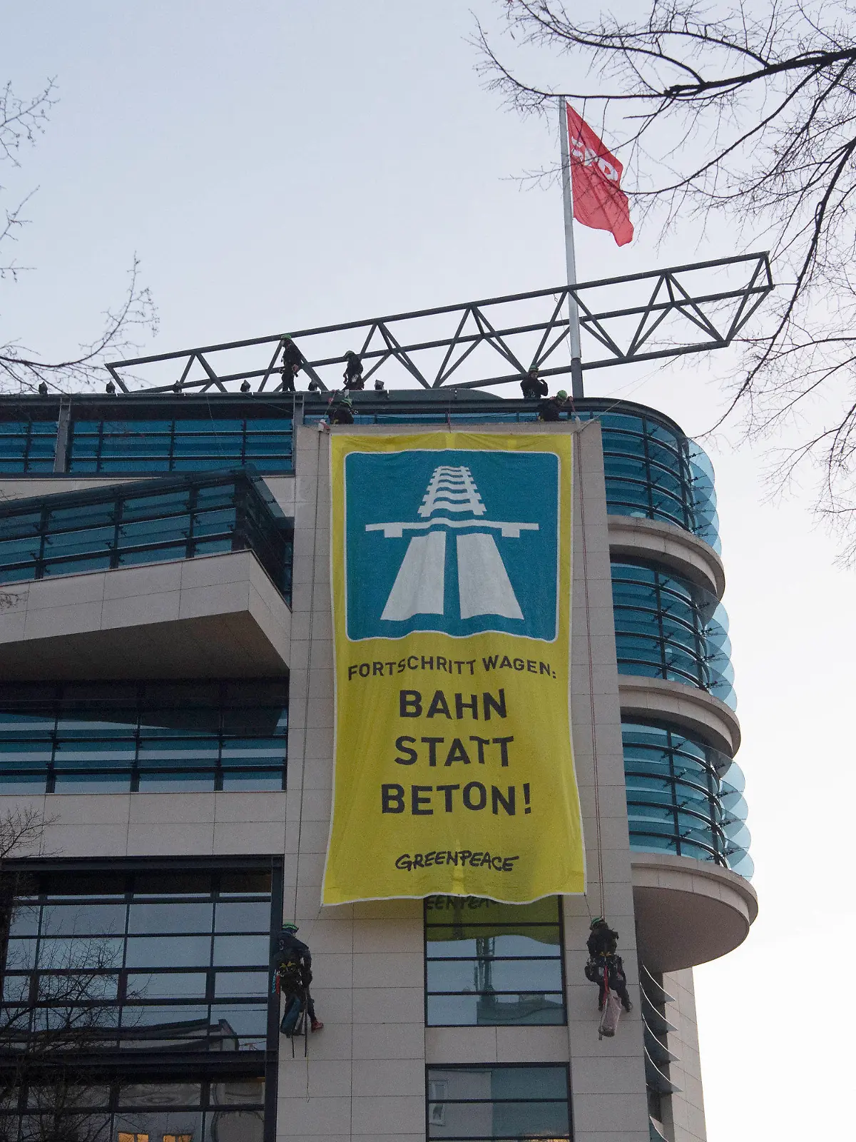 27.02.2023, Berlin: Ein übergroßes Transparent mit dem Logo der Autobahn haben Aktivisten der Umweltschutzgruppe Greenpeace vom Dach der SPD-Bundeszentrale aufgehangen. Dafür seilten sich zwei Umweltschützer vom Dach ab, um das Transparent entsprechend plazieren zu können. Weitere Aktivisten griffen unterstützend vom Dach aus ein. Greenpeace spricht sich gegen den Aus- und Weiterbau des Autobahnnetzes aus und fordert stattdessen die Bahnstrecken auszubauen. Foto: Paul Zinken/dpa +++ dpa-Bildfunk +++