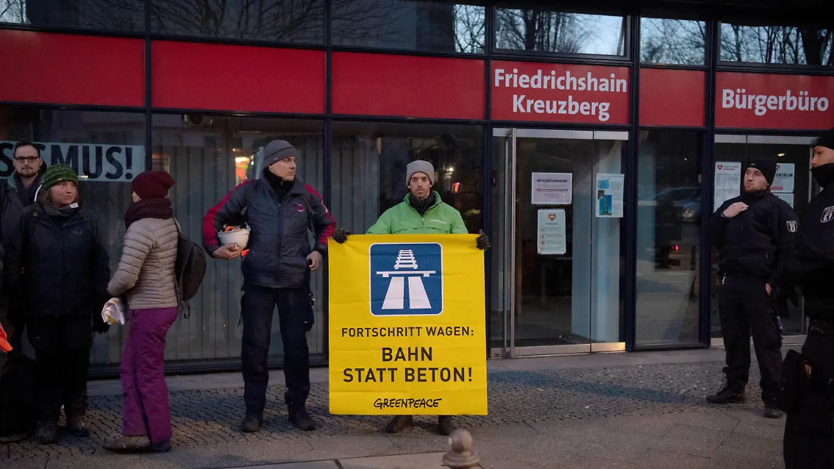 27.02.2023, Berlin: Ein von der Polizei festgesetzter Aktivist der Umweltschutz-Gruppe Greenpeace steht vor der Bundeszentrale der SPD. Aktivisten hatten zuvor ein übergroßes Transparent mit dem Logo der Autobahn vom Dach der SPD-Bundeszentrale aufgehangen. Dafür seilten sich zwei Umweltschützer vom Dach ab, um das Transparent entsprechend plazieren zu können. Weitere Aktivisten griffen unterstützend vom Dach aus ein. Greenpeace spricht sich gegen den Aus- und Weiterbau des Autobahnnetzes aus und fordert stattdessen die Bahnstrecken auszubauen. Foto: Paul Zinken/dpa +++ dpa-Bildfunk +++