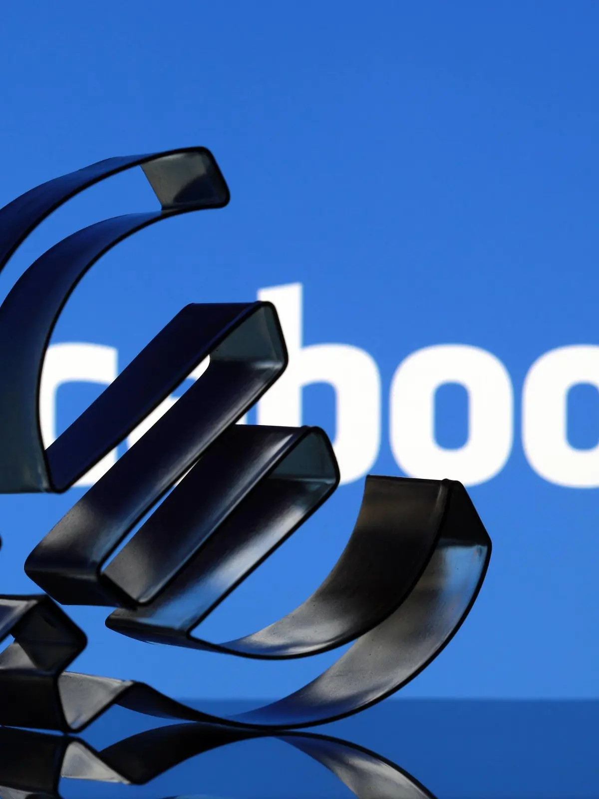 FOTOMONTAGE Euro Zeichen vor Facebook Emblem  