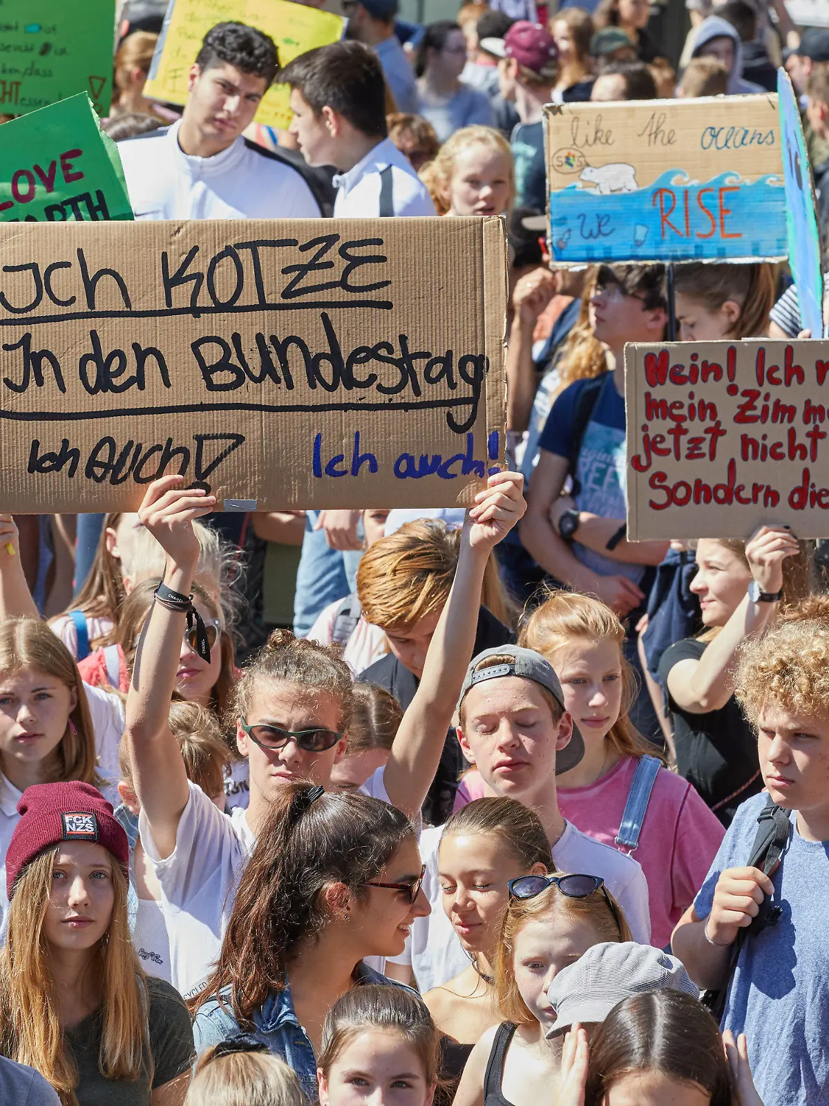 14.06.2019, Hamburg: Teilnehmer der Klima-Demonstration Fridays for Future halten auf dem Gänsemarkt unter anderem Transparente mit der Aufschrift: "Ich kotze in den Bundestag Ich auch! Ich auch!" oder "Nein! Ich räume mein Zimmer jetzt nicht auf sondern die Erde" hoch. Seit sechs Monaten gibt es die Aktion jetzt auch in der Hansestadt. Foto: Georg Wendt/dpa +++ dpa-Bildfunk +++