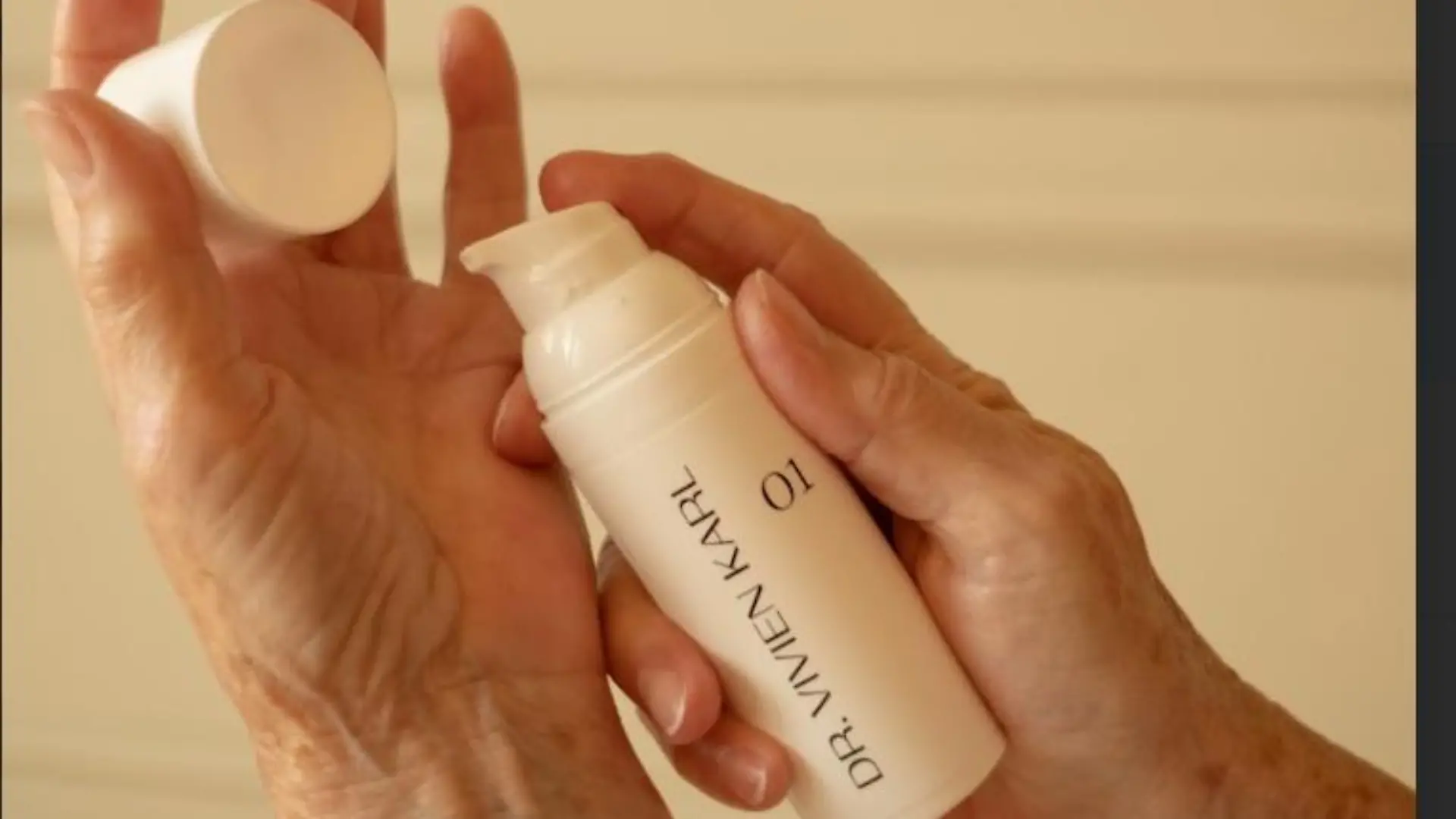 Hände halten Spender mit Creme von Dr. Vivien Karl