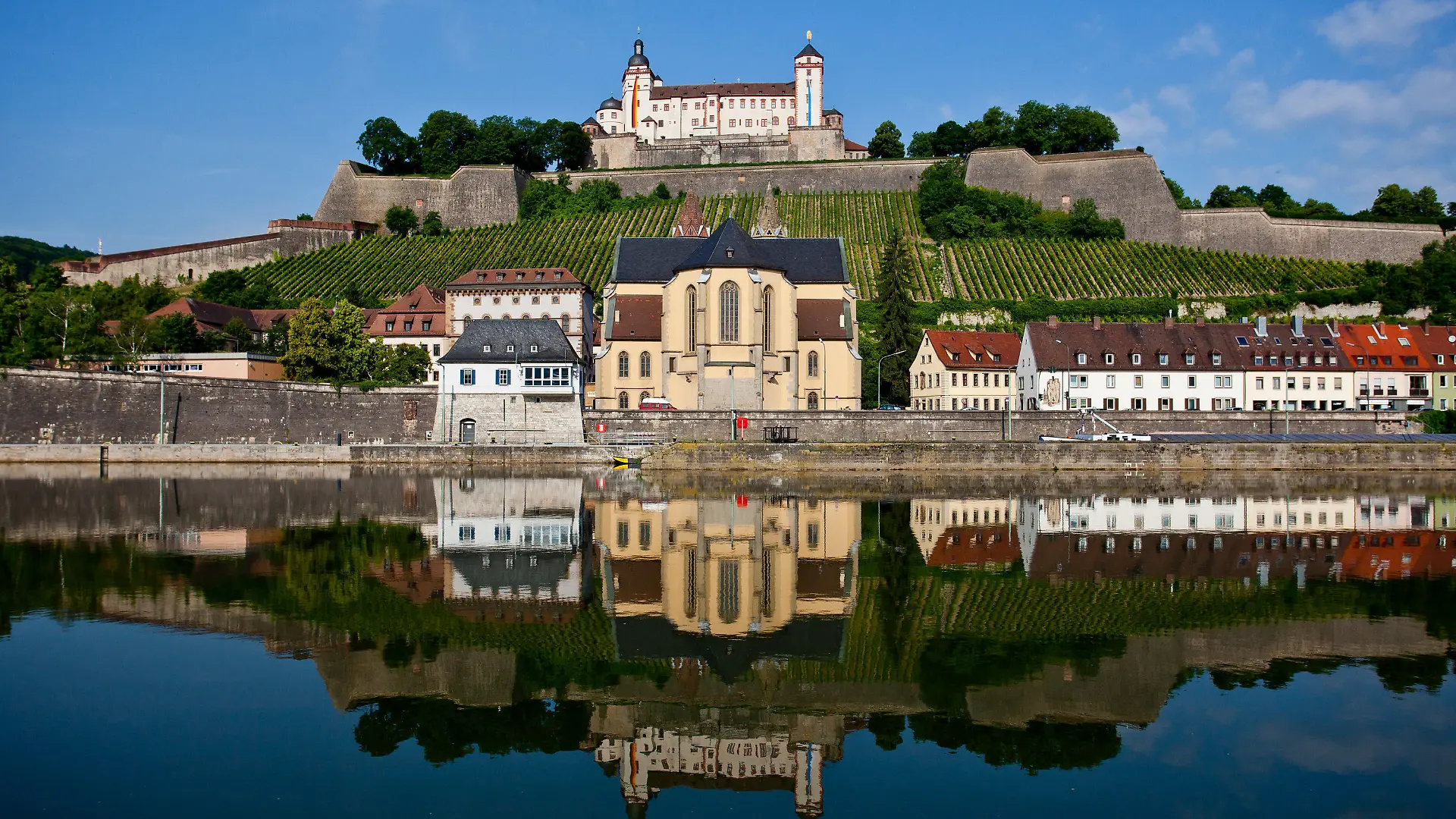 Die Festung Marienberg (o, M) spiegelt sich mit der darunter liegenden romanischen Basilika St. Burkard und anliegenden Häusern am Dienstag (19.06.2012) in Würzburg (Unterfranken) im Main. Laut Vorhersage der Meteorologen wird das Wetter in Bayern in den kommenden Tagen wechselhaft aber warm. Foto: Daniel Karmann dpa/lby +++(c) dpa - Bildfunk+++