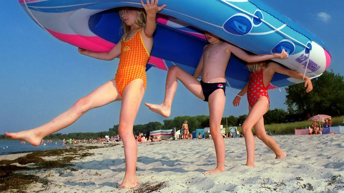 Tarnewitz (Mecklenburg-Vorpommern): Mit ihrem Schlauchboot laufen Kinder am 13.09.1999 am Strand von Tarnewitz (Landkreis Nordwestmecklenburg) Richtung Wasser. Bei hochsommerlichen Temperaturen bis zu 28 Grad und Sonnenschein zieht es Mitte September Urlauber und Tagesgäste an die Ostseeküste von Mecklenburg-Vorpommern. SCH01-130999) | Verwendung weltweit