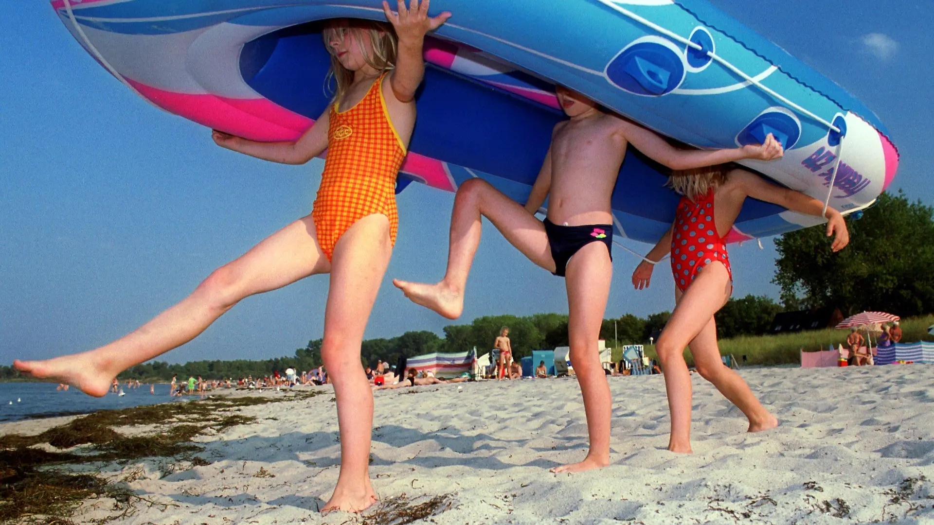 Tarnewitz (Mecklenburg-Vorpommern): Mit ihrem Schlauchboot laufen Kinder am 13.09.1999 am Strand von Tarnewitz (Landkreis Nordwestmecklenburg) Richtung Wasser. Bei hochsommerlichen Temperaturen bis zu 28 Grad und Sonnenschein zieht es Mitte September Urlauber und Tagesgäste an die Ostseeküste von Mecklenburg-Vorpommern.  SCH01-130999) | Verwendung weltweit