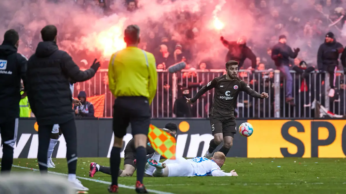Pyrotechnik in der Suedtribuene bei den Pauli Fans. Betim Fazlij FC St. Pauli 05 Abwehr, Verteidigung, Maurice Litka FC Hansa Rostock 28 Mittelfeld liegt am Boden. FC St. Pauli vs. Hansa Rostock, 2. Bundesliga, Hamburg, Millerntor Stadion, Spielzeit 2022/2023, 22.Spieltag, 26.02.2023 DFL REGULATIONS PROHIBIT ANY USE OF PHOTOGRAPHS AS IMAGE SEQUENCES AND/OR QUASI-VIDEO Foto:EIBNER/Stephanie Zerbe FC St. Pauli vs. Hansa Rostock, 2. Bundesliga, Hamburg, Spielzeit 2022/2023, 22.Spieltag, 26.02.2023 Hamburg *** Pyrotechnics in the Suedtribuene at the Pauli fans Betim Fazlij FC St Pauli 05 defense, defense, Maurice Litka FC Hansa Rostock 28 midfield is down FC St Pauli vs Hansa Rostock, 2 Bundesliga, Hamburg, Millerntor Stadion, season 2022 2023, 22 Spieltag, 26 02 2023 DFL REGULATES PROHIBIT ANY USE OF PHOTOGRAPHS AS IMAGE SEQUENCES AND OR QUASI VIDEO Foto EIBNER Stephanie Zerbe FC St Pauli vs Hansa Rostock, 2 Bundesliga, Hamburg, Spielzeit 2022 2023, 22 Spieltag, 26 02 2023 Hamburg Copyright: xStephaniexZerbe/xEibner-Pressefox EP_EER