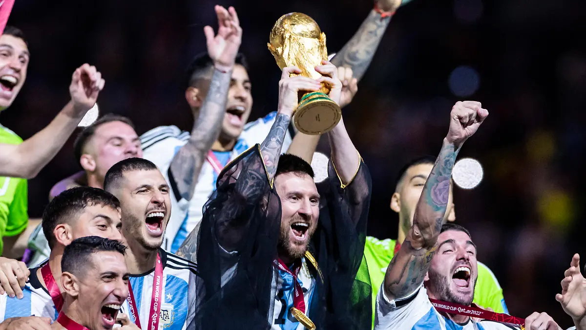 ARCHIV - 18.12.2022, Katar, Lusail: Fußball: WM, Argentinien - Frankreich, Finalrunde, Finale, Lusail Stadion, Argentiniens Lionel Messi jubelt mit WM - Pokal und seiner Mannschaft über den gewinn der Weltmeisterschaft. Am Montag ist Messi Favorit auf die Auszeichnung als Weltfußballer 2022. (zu dpa: «Kein Umhang, kein Hahn: Messi vor nächster Weltfußballer-Krönung») Foto: Tom Weller/dpa +++ dpa-Bildfunk +++