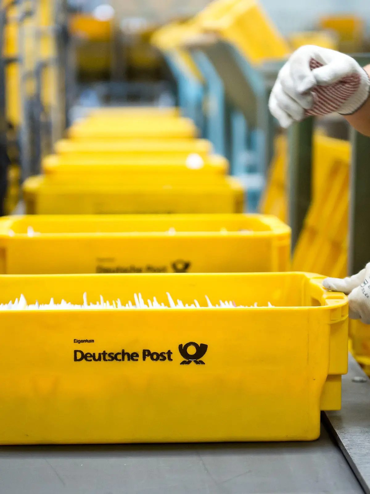 ARCHIV - Eine Mitarbeiterin der Deutschen Post sortiert am 15.07.2015 im Briefverteilzentrum in Waiblingen (Baden-Württemberg) Briefe, die in einer Kiste mit der Aufschrift "Deutsche Post" liegen. Foto: Daniel Naupold/dpa (zu dpa "Deutsche Post will britischen Paketdienstleister UK Mail übernehmen" vom 28.09.2016) +++(c) dpa - Bildfunk+++