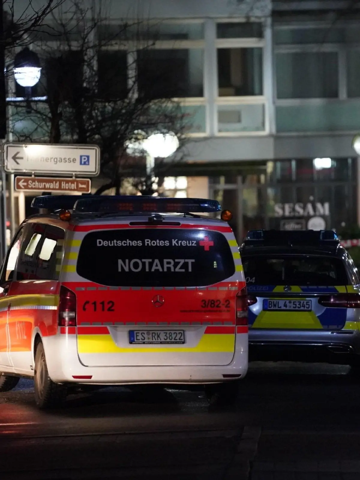 25.02.2023, Baden-Württemberg, Plochingen: Fahrzeuge von Polizei und Rotem Kreuz stehen in der Nähe des Tatorts. In Plochingen (Landkreis Esslingen) ist in der Nacht zum Samstag ein Mann durch mindestens einen Schuss schwer verletzt worden. Lebensgefahr bestehe nicht, sagte eine Polizeisprecherin. Die Polizei sei mit starken Kräften vor Ort, zuvor sei auch mit einem Hubschrauber nach dem Täter oder den Tätern gefahndet worden. Bisher blieb die Suche vergeblich. Foto: Kohls/SDMG/dpa +++ dpa-Bildfunk +++