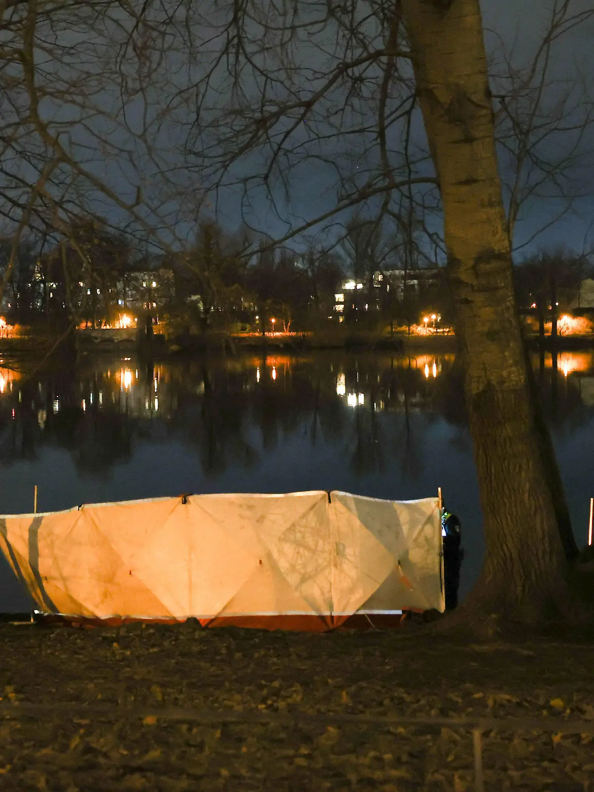 27.02.2023, Berlin: Ein Sichtschutz ist am Ufer des Weißen Sees in Berlin-Pankow aufgestellt. Am Ufer des Sees wurden zwei Leichen gefunden. Es soll sich um eine Frau und ein Kleinkind handeln, teilte die Polizei mit. Foto: Jörg Carstensen/dpa +++ dpa-Bildfunk +++