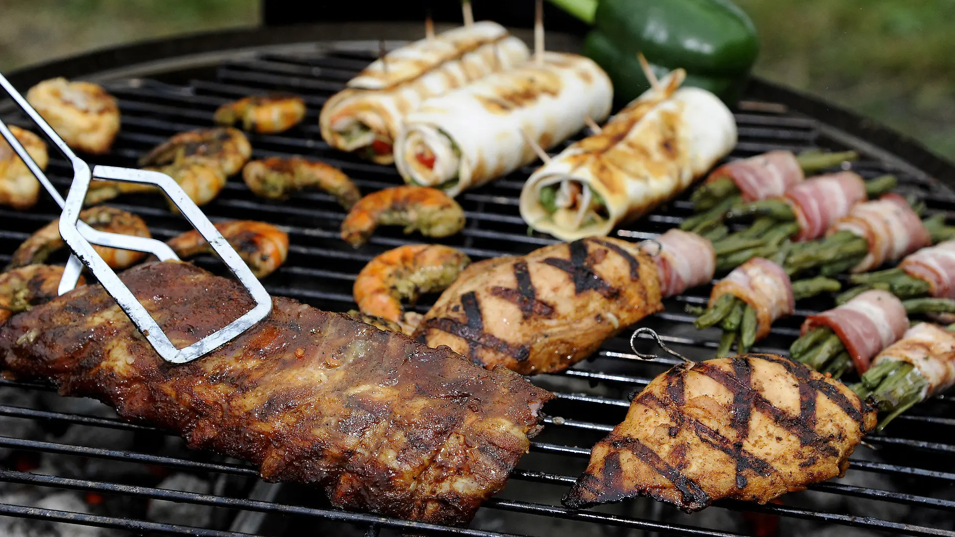ARCHIV - Spareribs, Gemüse, gefüllte Hühnerbrust und Garnelen liegen am 19.05.2013 während der 18. Deutschen Grillmeisterschaft in Göppingen auf dem Grill von Michael Hoffmann, Teamchef des Grillteam Gut Glut e.V. Mit Grillgabel, Schürze und ganz viel Fleisch treten am Sonntag in Hennef bei Bonn die besten «Grilleure» der Republik zur Deutschen Grill- und BBQ-Meisterschaft an. Titelverteidiger und BBQ-Meister ist Michael Hoffmann aus Rösrath. Im Gespräch mit der Deutschen Presse-Agentur erklärt der 47-Jährige unter anderem, was für ihn am Grill ein absolutes No-Go ist. Foto: Daniel Maurer/dpa +++(c) dpa - Bildfunk+++