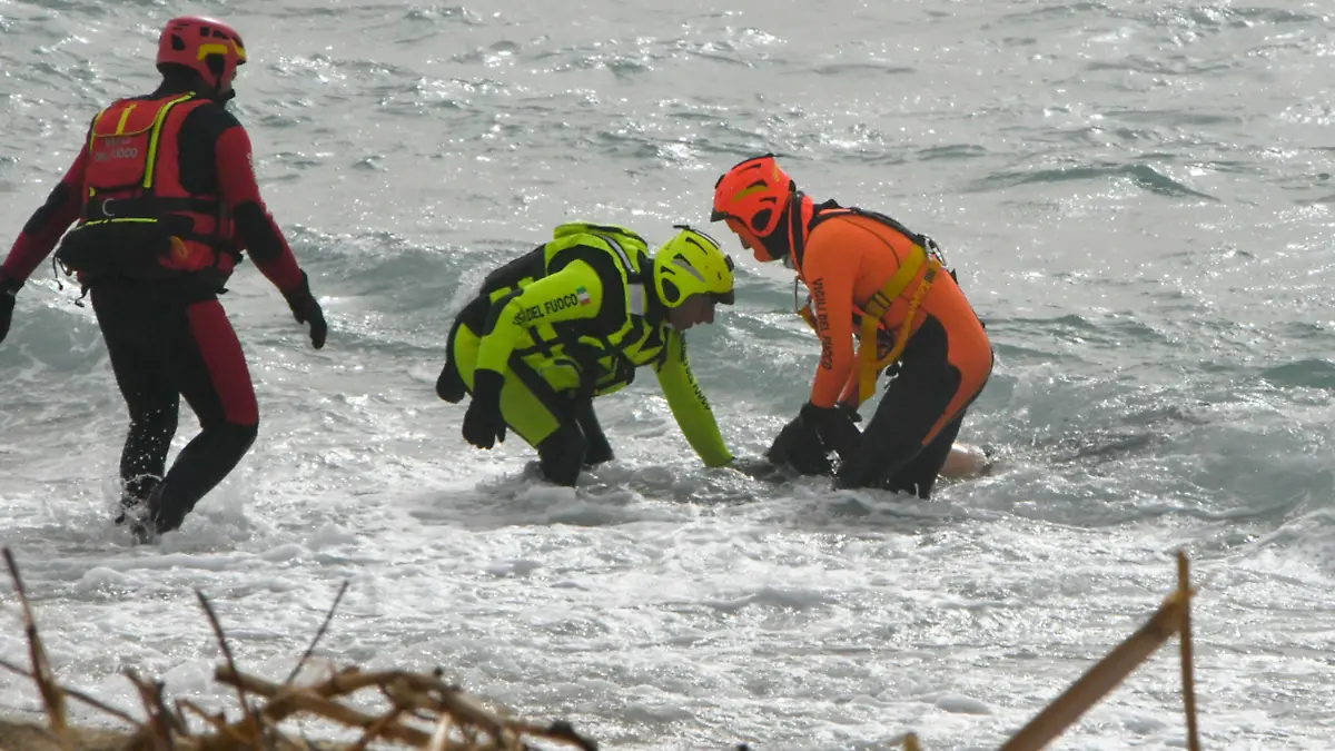 26.02.2023, Italien, Cutro: *** ATTENTION EDITORS GRAPHIC CONTENT *** Rettungskräfte bergen eine Leiche an einem Strand in der Nähe von Cutro, Süditalien, nachdem ein Boot mit Migranten bei rauer See auseinandergebrochen war. Bei einem Bootsunglück mit Migranten an der süditalienischen Küste sind Medienberichten zufolge mehrere Menschen ums Leben gekommen. Foto: Giuseppe Pipita/AP/dpa +++ dpa-Bildfunk +++