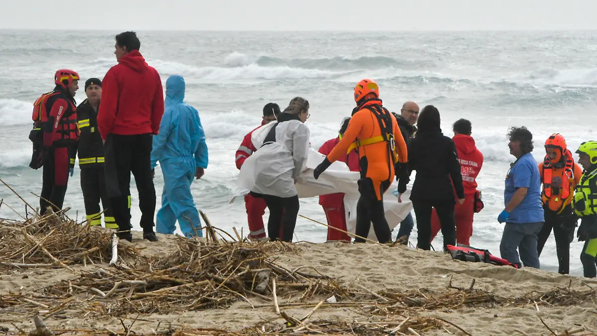 26.02.2023, Italien, Cutro: Rettungskräfte bergen eine Leiche an einem Strand in der Nähe von Cutro, Süditalien, nachdem ein Boot mit Migranten bei rauer See auseinandergebrochen war. Bei einem Bootsunglück mit Migranten an der süditalienischen Küste sind Medienberichten zufolge mehrere Menschen ums Leben gekommen. Foto: Giuseppe Pipita/AP/dpa +++ dpa-Bildfunk +++