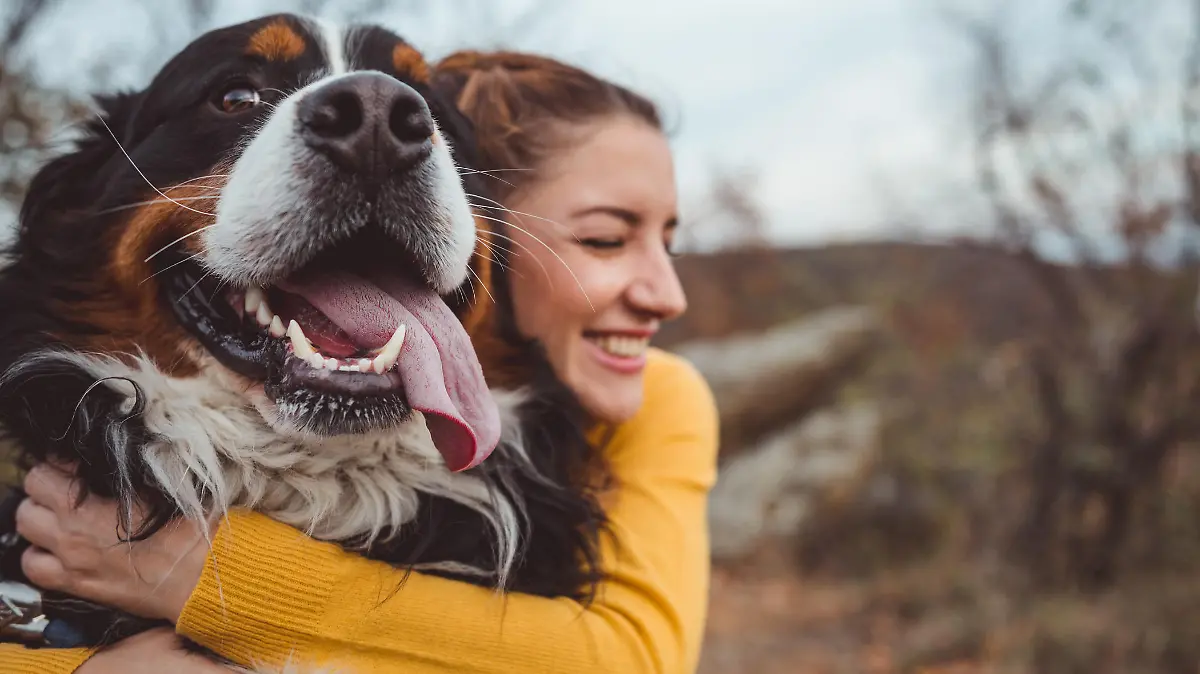 Frau umarmt einen Hund.