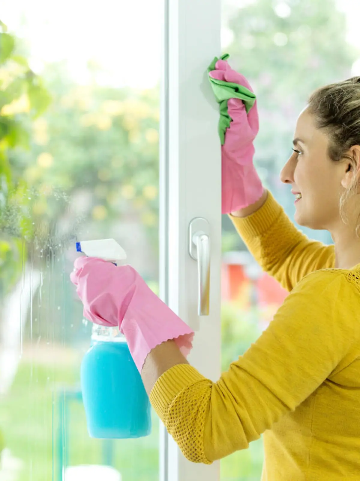 Frau putzt Fenster