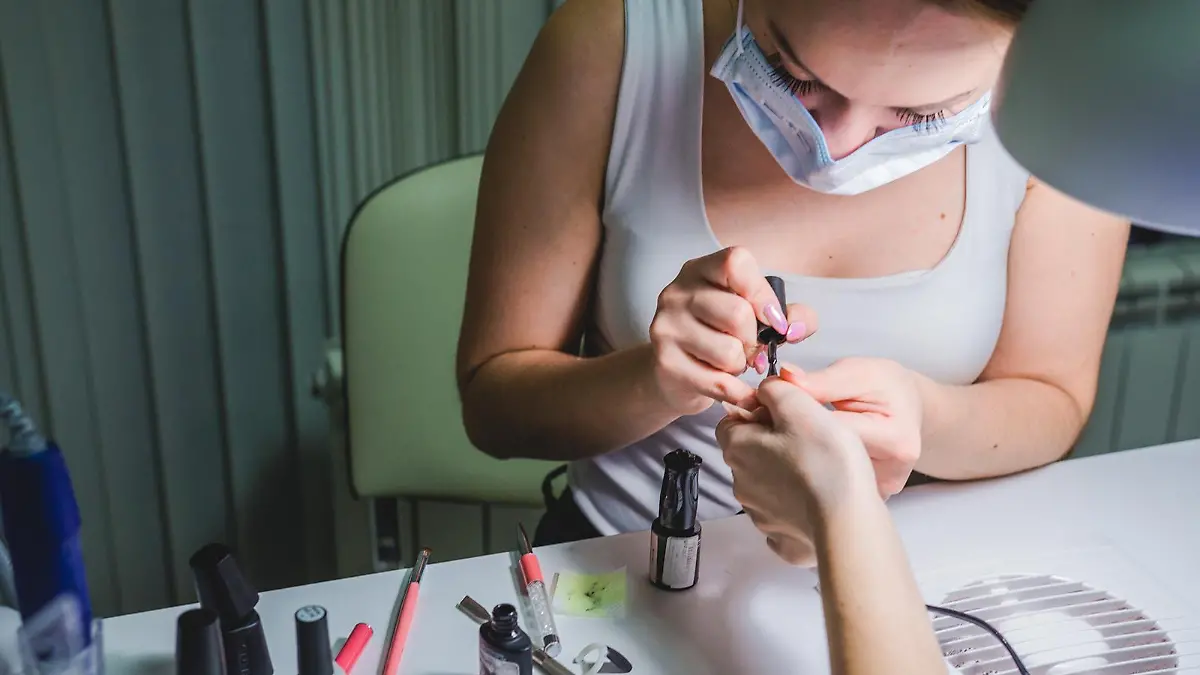 Nagelstudio-Mitarbeiterin gibt Frau eine Maniküre