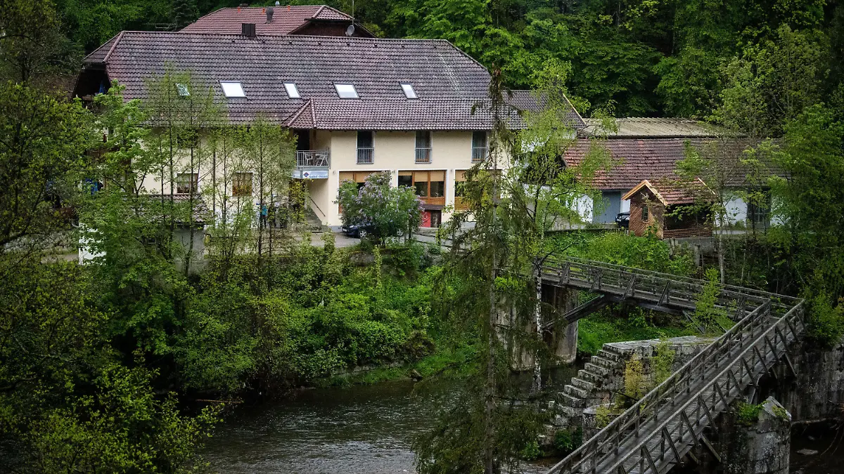 11.05.2019, Bayern, Passau: Eine Pension steht von Bäumen umgeben an der Ilz. Drei tote Personen sind in einem Zimmer der Pension gefunden worden. Den Angaben zufolge stammen die Toten aus Niedersachsen und Rheinland-Pfalz. Es sei noch völlig offen, wie die drei Menschen ums Leben kamen, sagte ein Sprecher der Polizei. Foto: Lino Mirgeler/dpa - ACHTUNG: Schild an der Pension wurde aus rechtlichen Gründen gepixelt +++ dpa-Bildfunk +++