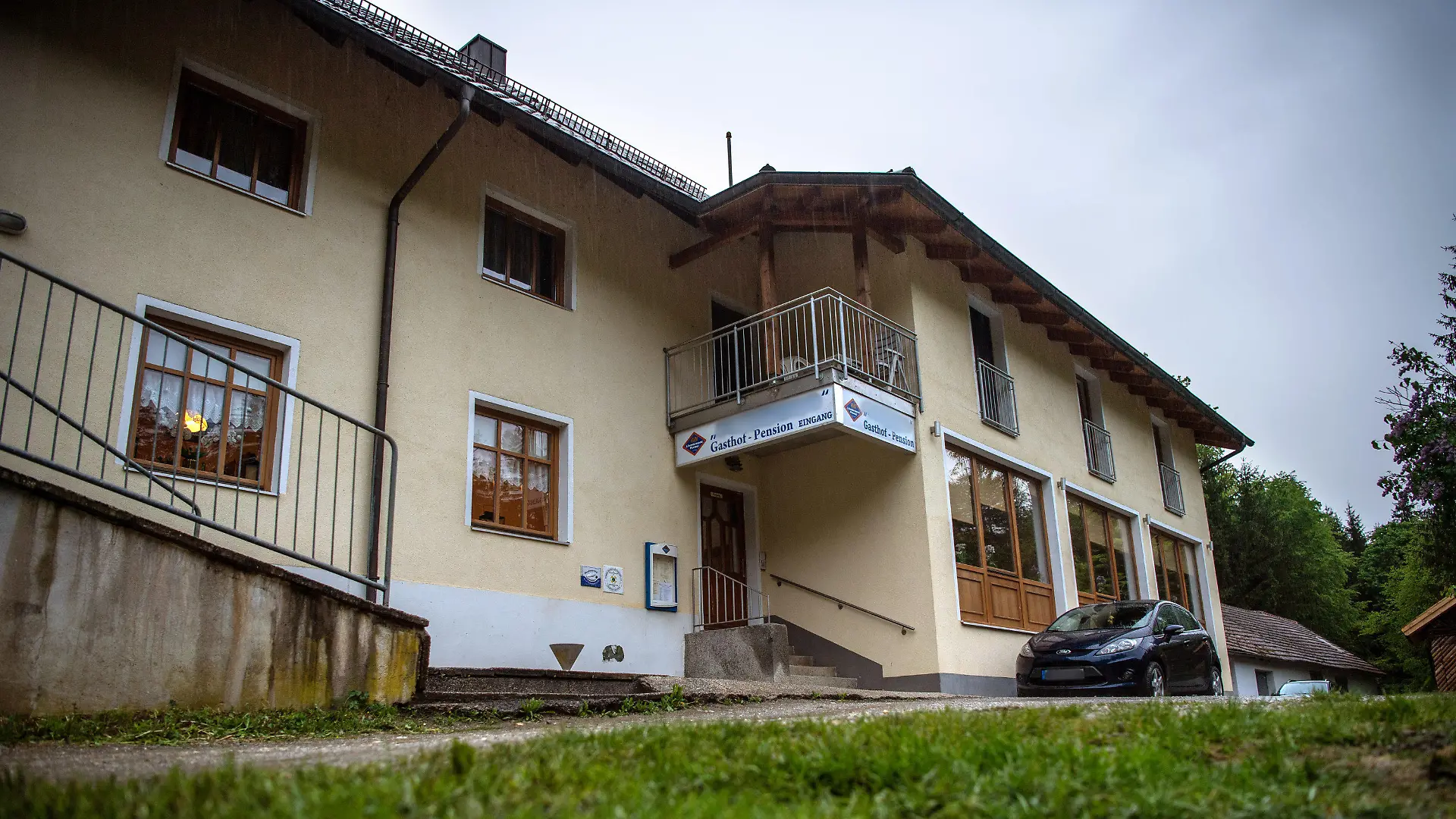 11.05.2019, Bayern, Passau: Eine Pension steht nahe der Ilz. Drei tote Personen sind in einem Zimmer der Pension gefunden worden. Den Angaben zufolge stammen die Toten aus Niedersachsen und Rheinland-Pfalz. Es sei noch völlig offen, wie die drei Menschen ums Leben kamen, sagte ein Sprecher der Polizei. Foto: Lino Mirgeler/dpa - ACHTUNG: Das Schild an der Pension und das Nummernschild am Auto wurden aus rechtlichen Gründen gepixelt +++ dpa-Bildfunk +++
