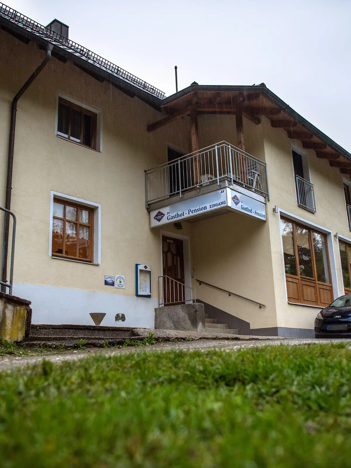 11.05.2019, Bayern, Passau: Eine Pension steht nahe der Ilz. Drei tote Personen sind in einem Zimmer der Pension gefunden worden. Den Angaben zufolge stammen die Toten aus Niedersachsen und Rheinland-Pfalz. Es sei noch völlig offen, wie die drei Menschen ums Leben kamen, sagte ein Sprecher der Polizei. Foto: Lino Mirgeler/dpa - ACHTUNG: Das Schild an der Pension und das Nummernschild am Auto wurden aus rechtlichen Gründen gepixelt +++ dpa-Bildfunk +++