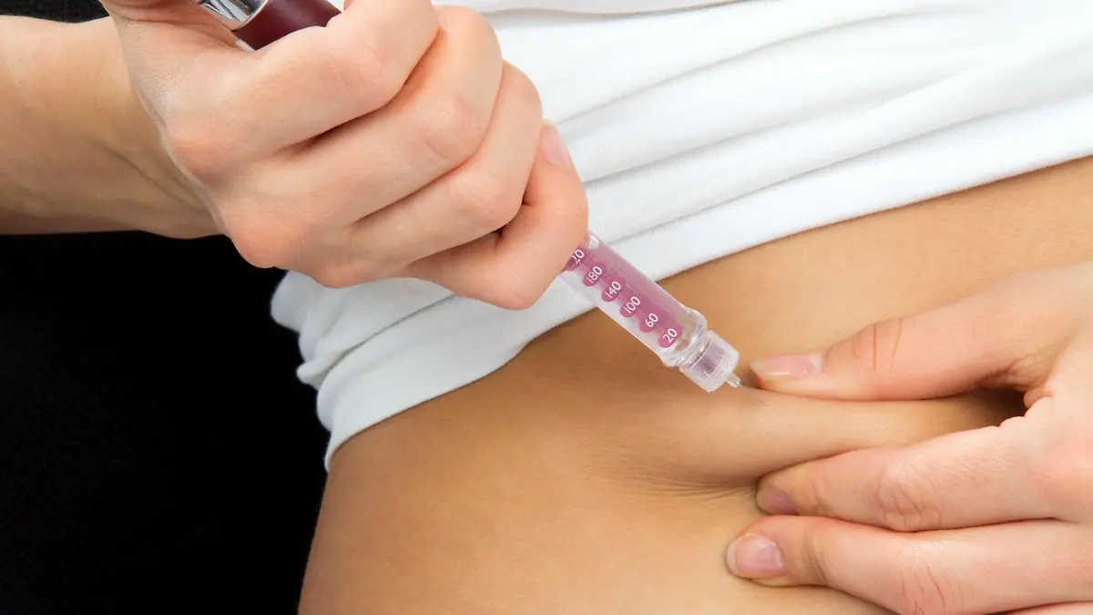 Insulin dependent Diabetes patient make a subcutaneous injection by single use syringe with needle and  insulin into abdomen by doctor prescription 