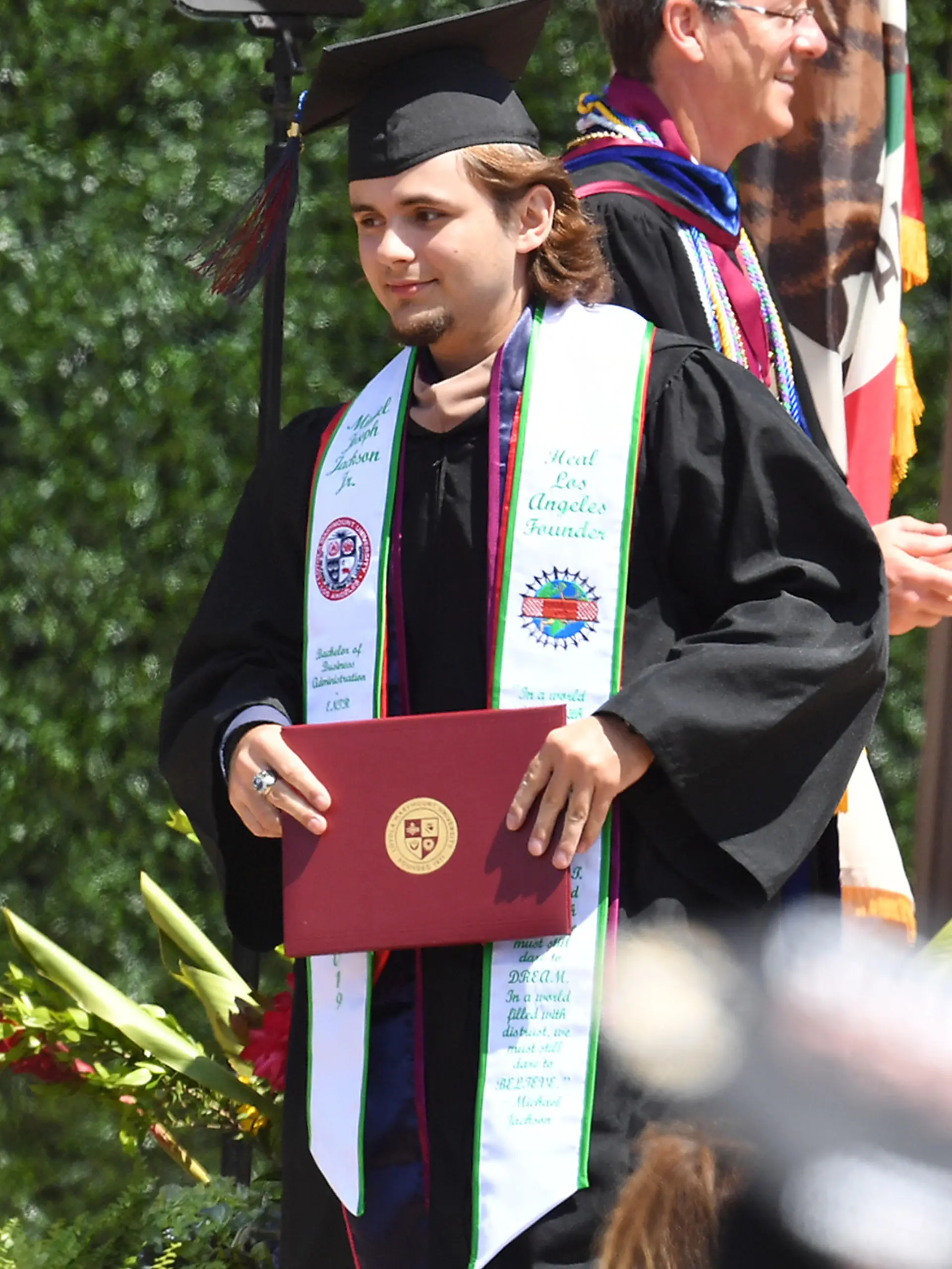 EXCLUSIVE: Prince Jackson graduates from college wearing a cap and gown with a tribute to his late father Michael Jackson written on it while his grandma Katherine Jackson looks on supporting him at his graduation ceremony at Loyola Marymount University in L.A. on Saturday. Prince wore a scarf with his full first name embroidered "Michael Joseph Jackson" on one side and an inspiring quote by his father Michael Jackson on the other side which read "In a world filled with hate we must still dare to hope. In a world filled with anger we must still dare to comfort. In world filled with despair we must still dare to dream. In a world filled with mistrust we must still dare to Believe. - Michel Jackson"

Pictured: Prince Jackson
Ref: SPL5088761 110519 EXCLUSIVE
Picture by: Garrett A. Cheen (F) / SplashNews.com

Splash News and Pictures
Los Angeles: 310-821-2666
New York: 212-619-2666
London: 0207 644 7656
Milan: 02 4399 8577
photodesk@splashnews.com

World Rights
