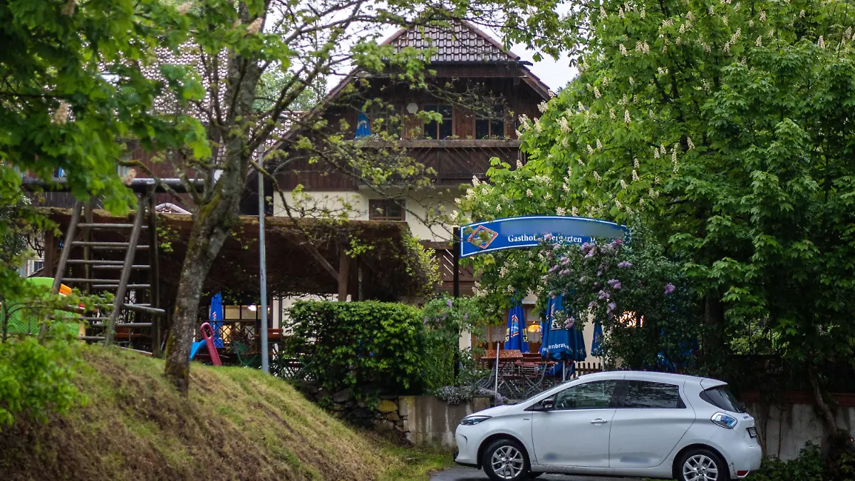 11.05.2019, Bayern, Passau: Eine Pension steht nahe der Ilz zwischen Bäumen. Drei tote Personen sind in einem Zimmer der Pension gefunden worden. Den Angaben zufolge stammen die Toten aus Niedersachsen und Rheinland-Pfalz. Es sei noch völlig offen, wie die drei Menschen ums Leben kamen, sagte ein Sprecher der Polizei. Foto: Lino Mirgeler/dpa - ACHTUNG: Das Schild an der Pension und Aufkleber am Auto wurden aus rechtlichen Gründen gepixelt +++ dpa-Bildfunk +++