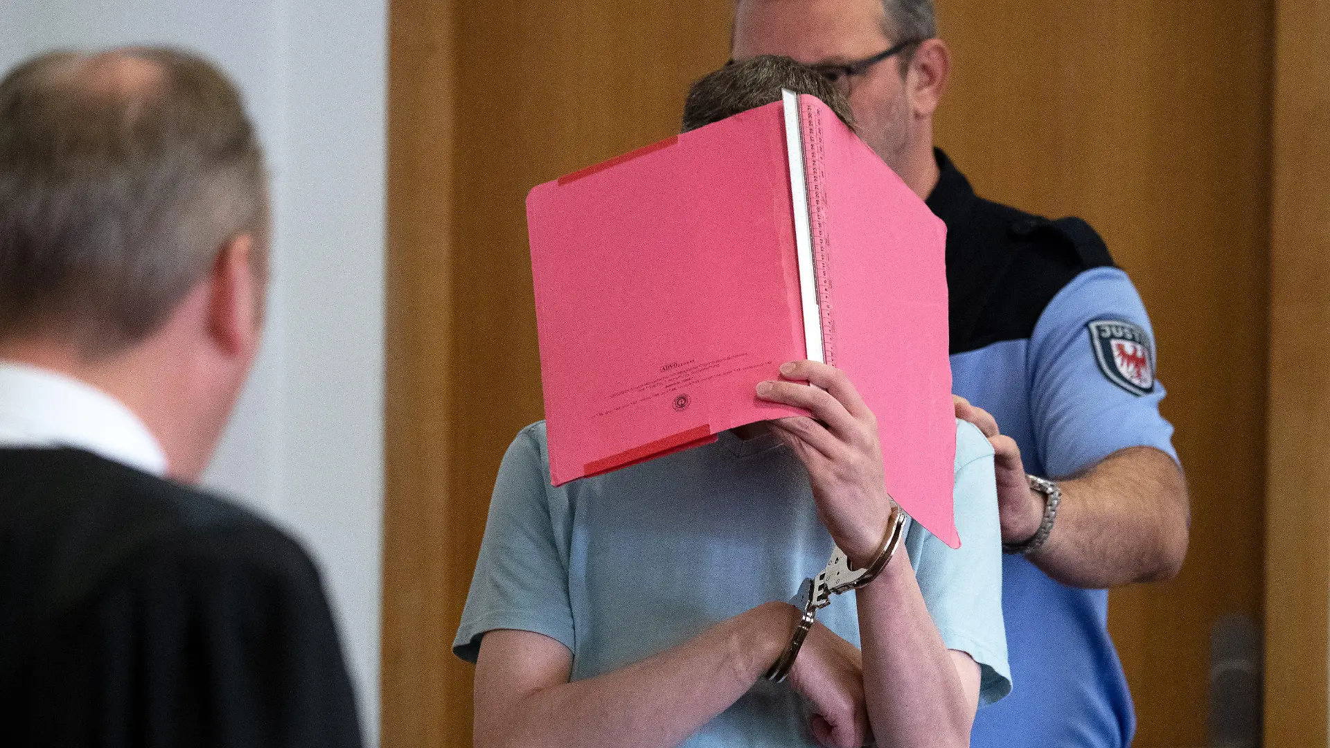 10.05.2019, Brandenburg, Potsdam: Der Mörder Silvio S. wird von einem Justizbeamten in einen Verhandlungssaal des Landgerichtes Potsdam geführt. Nach einer Entscheidung des Bundesgerichtshofs muss das Landgericht Potsdam erneut prüfen, ob bei dem verurteilten Mörder der beiden Jungen Elias und Mohamed ein Hang zur Begehung weiterer schwerer Straftaten vorliegt und eine Sicherungsverwahrung nach der Haft erforderlich ist. Foto: Ralf Hirschberger/dpa +++ dpa-Bildfunk +++