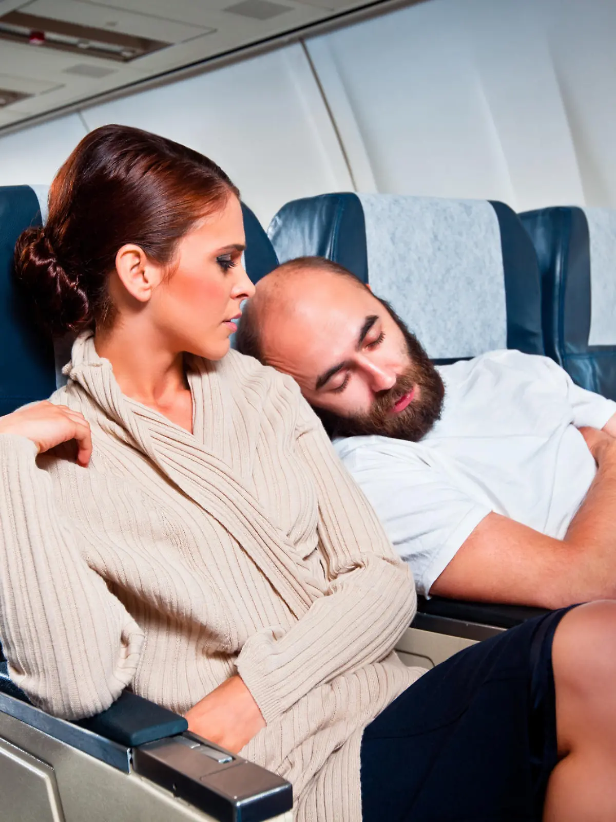 Mann schläft auf Schulter von Sitznachbarin im Flieger ein.