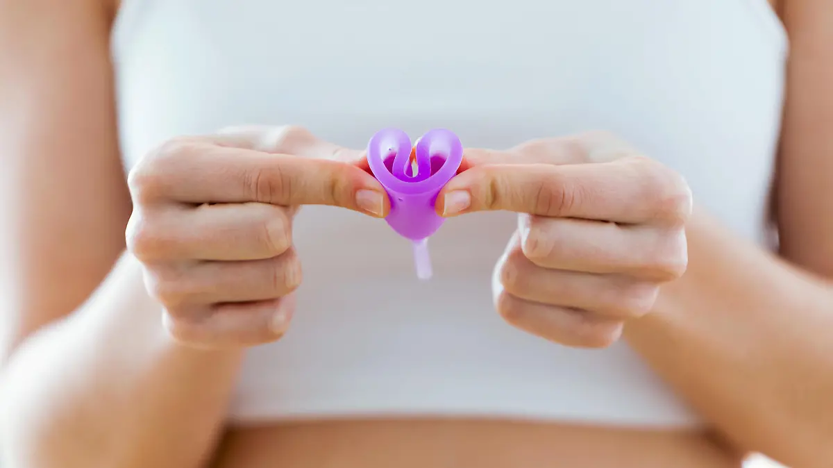 Frau hält Menstruationstasse