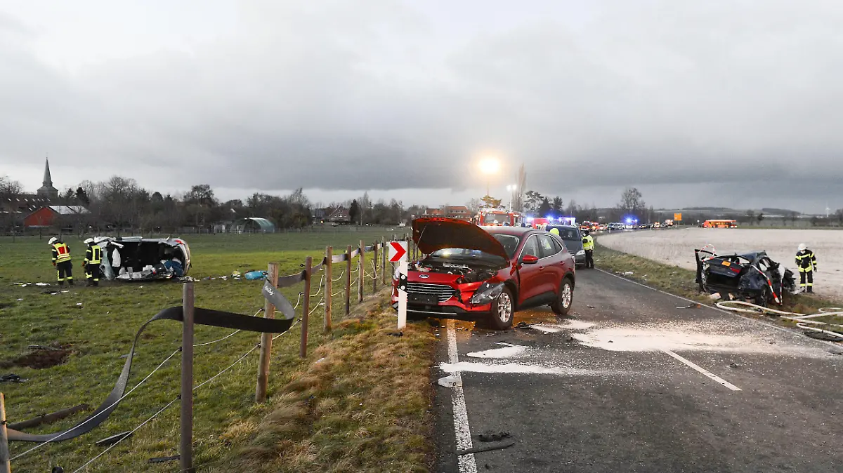 ARCHIV - 25.02.2022, Niedersachsen, Barsinghausen: Ein zerstörtes Auto (l) liegt auf einer Wiese. Bei dem Unfall bei Barsinghausen in der Region Hannover mit mehreren beteiligten Fahrzeugen kam ein Kind ums Leben, ein weiteres Kind starb kurze Zeit später im Krankenhaus. Zudem gab es mehrere Verletzte. (zu dpa: «Frau steht nach Autorennen wegen Mordes vor Gericht») Foto: Frank Tunnat/dpa +++ dpa-Bildfunk +++