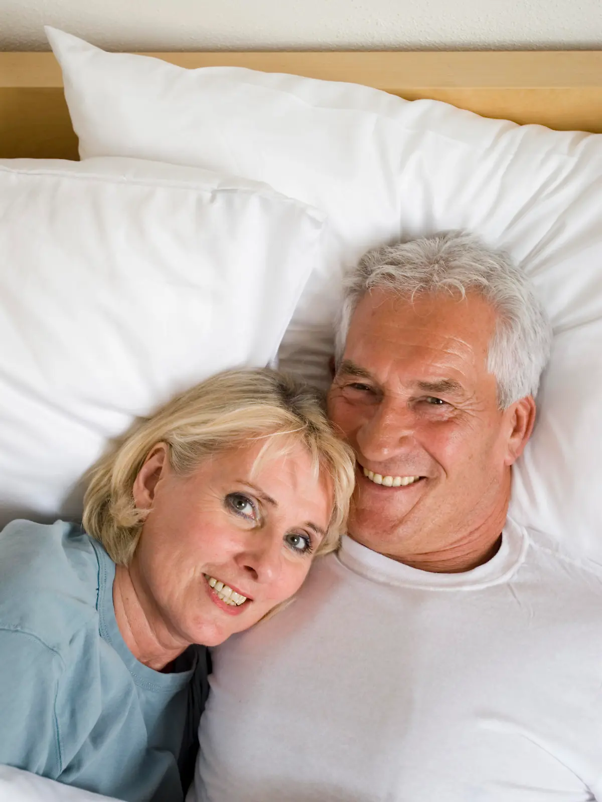 mature couple lying smiling in bed Keine Weitergabe an Drittverwerter., Royalty free: Bei werblicher Verwendung Preis auf Anfrage