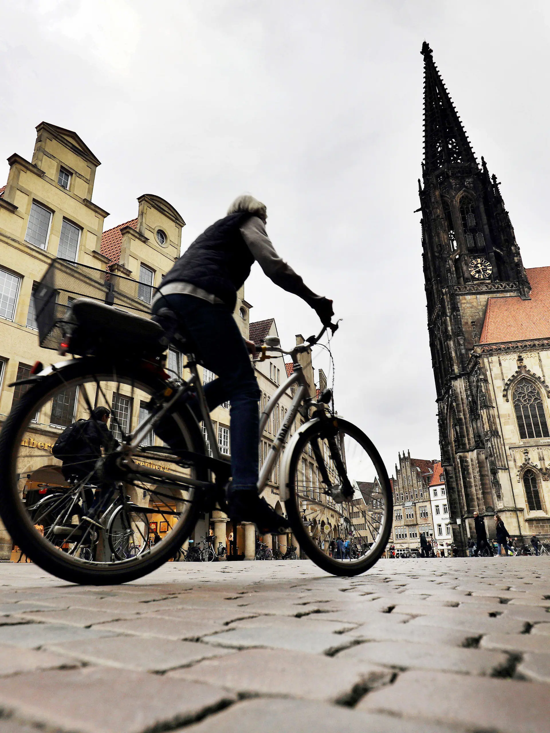 ARCHIV - 05.04.2017, Nordrhein-Westfalen, Münster: Ein Radfahrer fährt über den Prinzipalmarkt. (zu dpa "Reiseführer kürt entspannte Städte wie Leipzig und Münster") Foto: Oliver Berg/dpa +++ dpa-Bildfunk +++