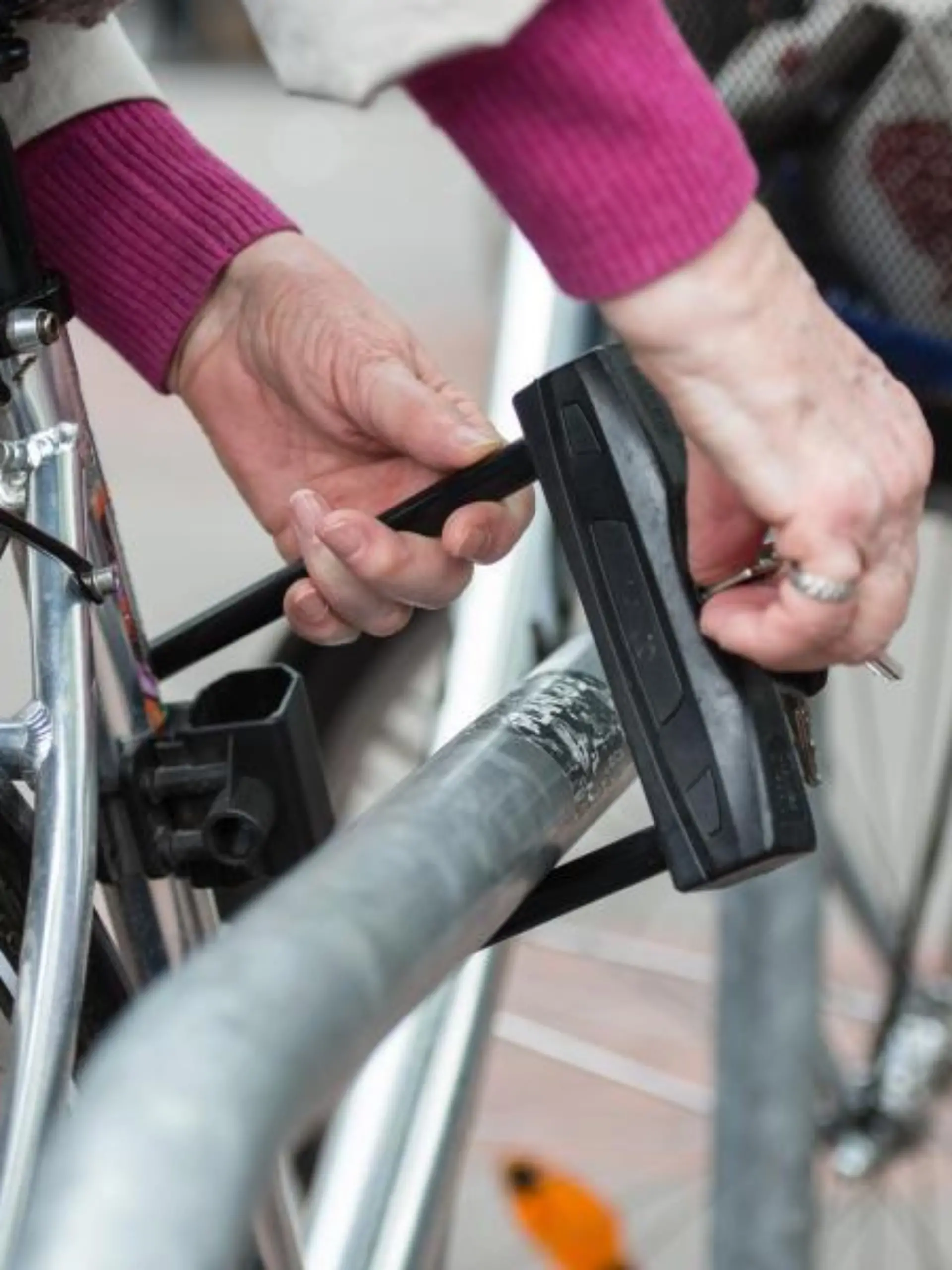 Eine Frau schließt ihr Fahrrad an einem Metallbügel an