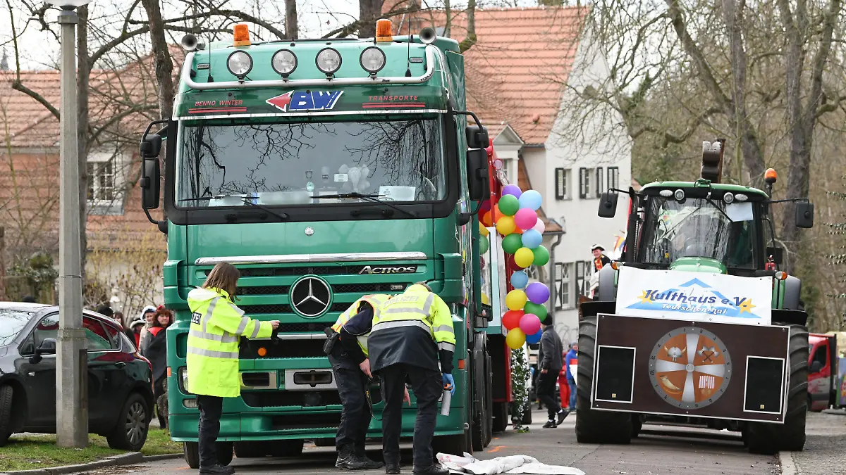 20.02.2023, Sachsen-Anhalt, Halle (Saale): Die Polizei ermittelt den Unfallhergang beim Karnevalsumzug, wobei eine Person von einem LKW erfasst und schwer verletzt wurde. Gleich am Startpunkt des Halleschen Rosenmontagsumzuges kam es zu diesem schweren Unfall. Der Umzug wurde daher abgebrochen. Foto: Heiko Rebsch/dpa +++ dpa-Bildfunk +++