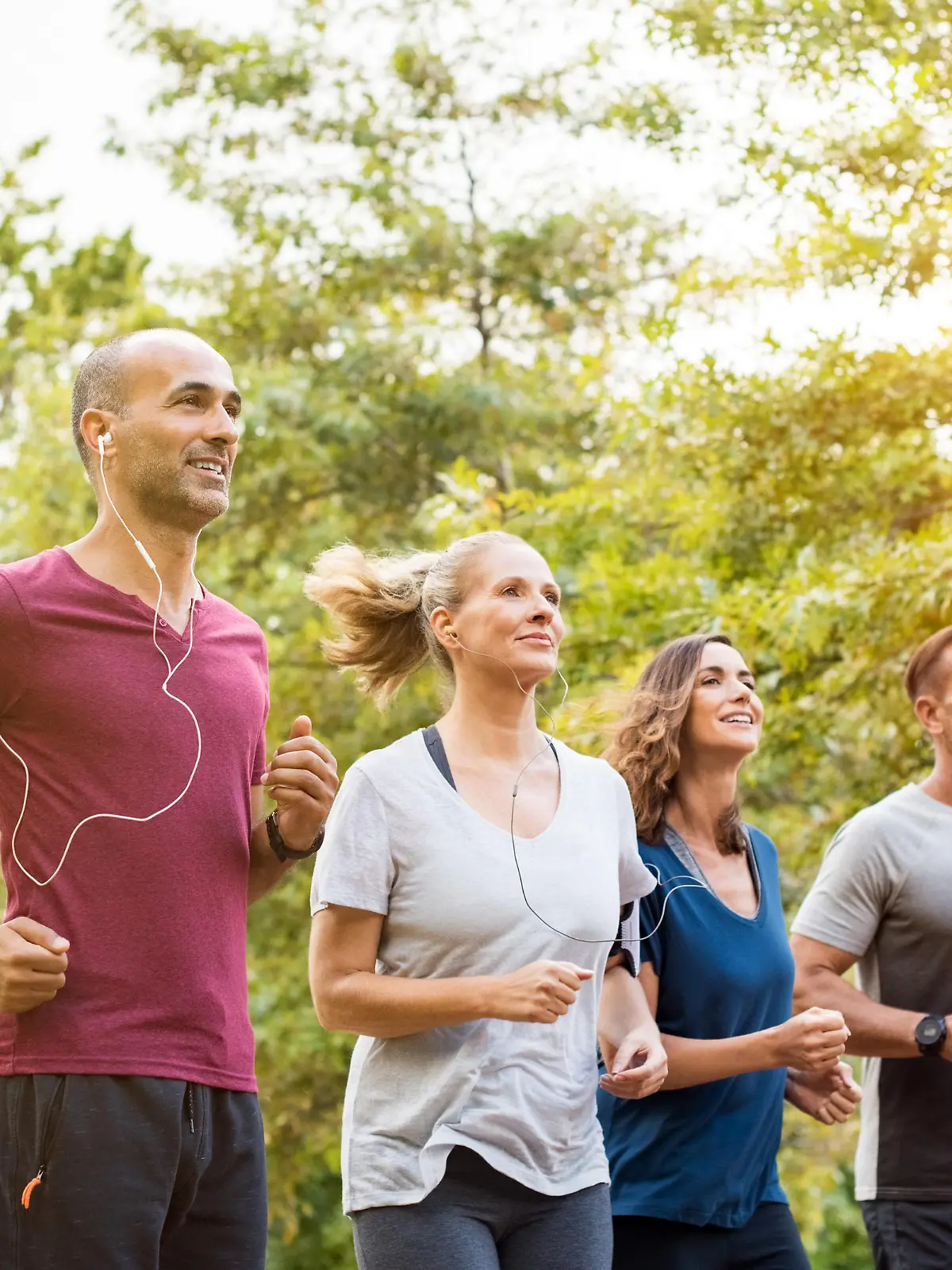 Runners team on morning training together. Group of mature athletes running outside in the park. Group of senior healthy people running outdoor and doing fitness exercises in summer."r