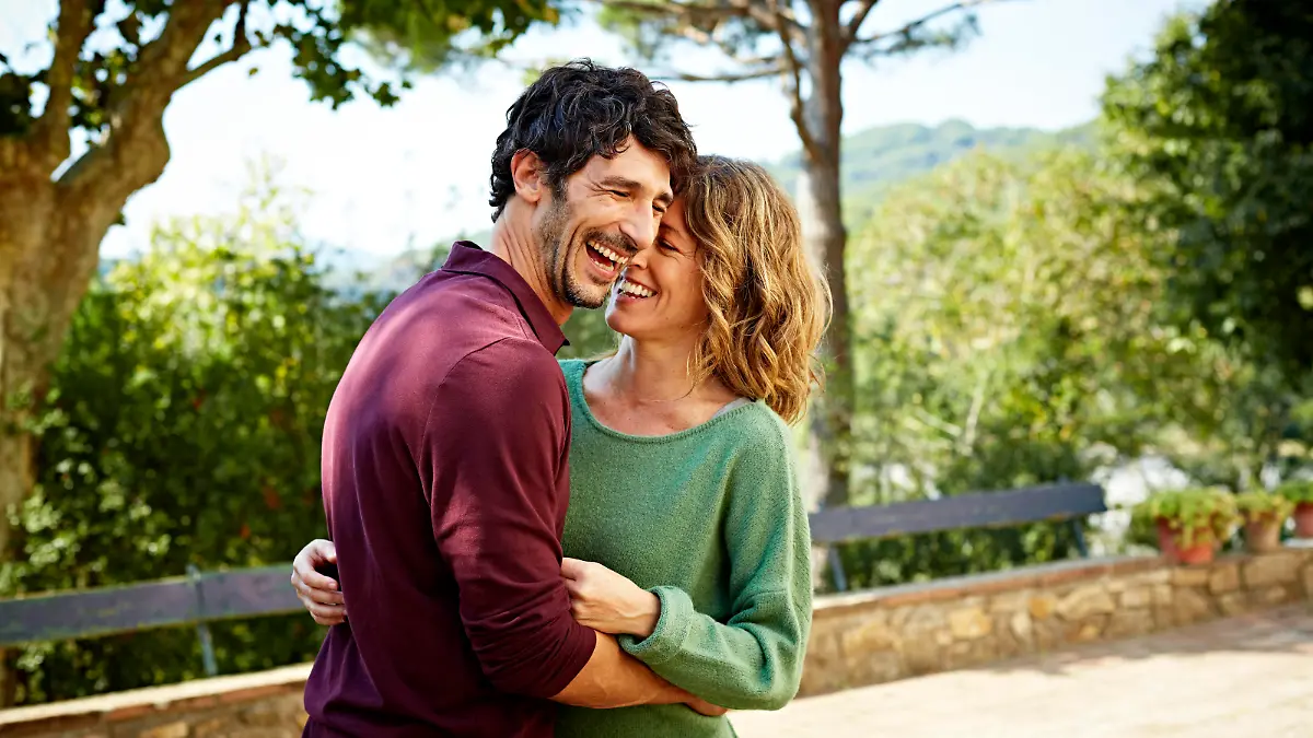 Cheerful mid adult couple embracing in park