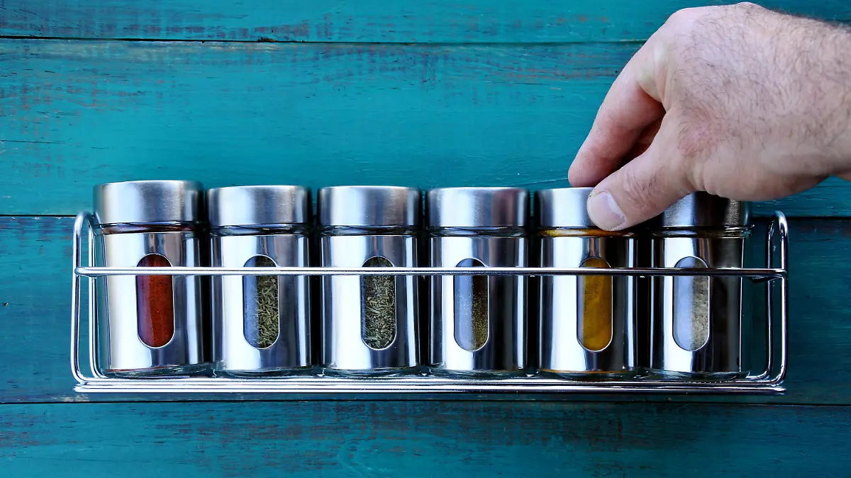 Chef hand returning spice into a spice rack. Food background. copy space