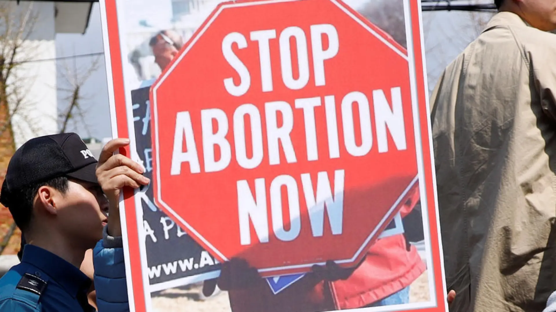 A pro-abortion law protester holds up a banner in sight of anti-abortion law protesters (not pictured) during a rally to support the abortion law in front of the constitutional court in Seoul, South Korea, April 11, 2019.   REUTERS/Kim Hong-Ji