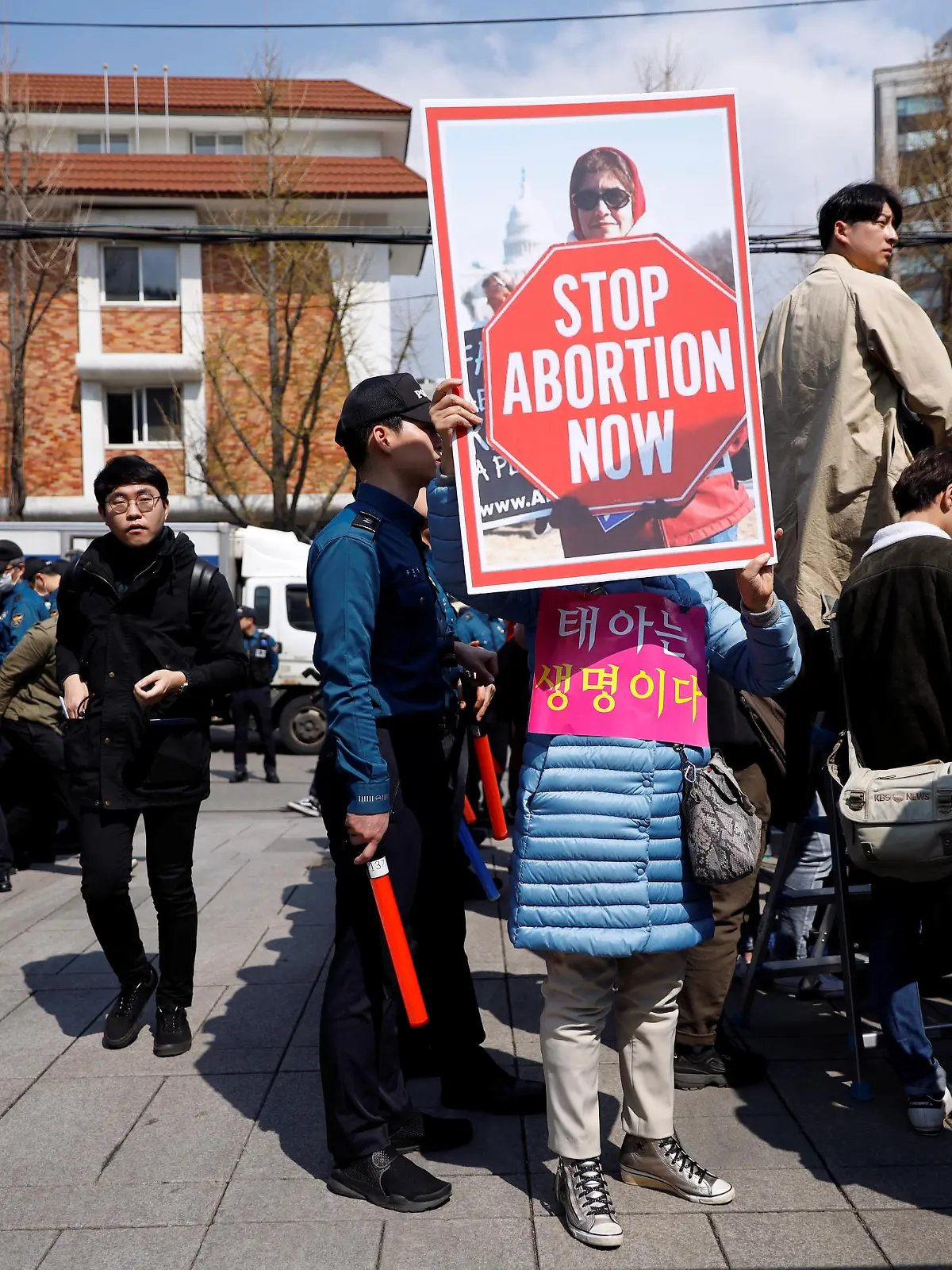 A pro-abortion law protester holds up a banner in sight of anti-abortion law protesters (not pictured) during a rally to support the abortion law in front of the constitutional court in Seoul, South Korea, April 11, 2019.   REUTERS/Kim Hong-Ji