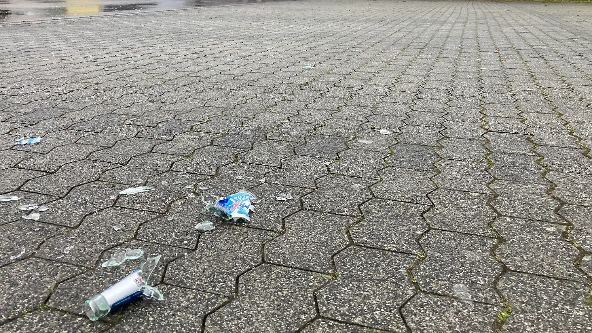 17.02.2023, Rheinland-Pfalz, Trier: Scherben liegen auf einem Parkplatz nach einem Polizeieinsatz an einer Disko. Nach einem Streit haben rund 40 Menschen in der Nacht zum Freitag eine Gruppe von Polizisten angegriffen. Die Einsatzkräfte seien mit Stangen, Besen, Schaufeln und Glasflaschen attackiert worden, teilte die Polizei mit. Mindestens fünf Beamte wurden verletzt. (zu dpa: «Angriff auf Polizeieinsatz in Trier - fünf Beamte verletzt») Foto: Birgit Reichert/dpa +++ dpa-Bildfunk +++