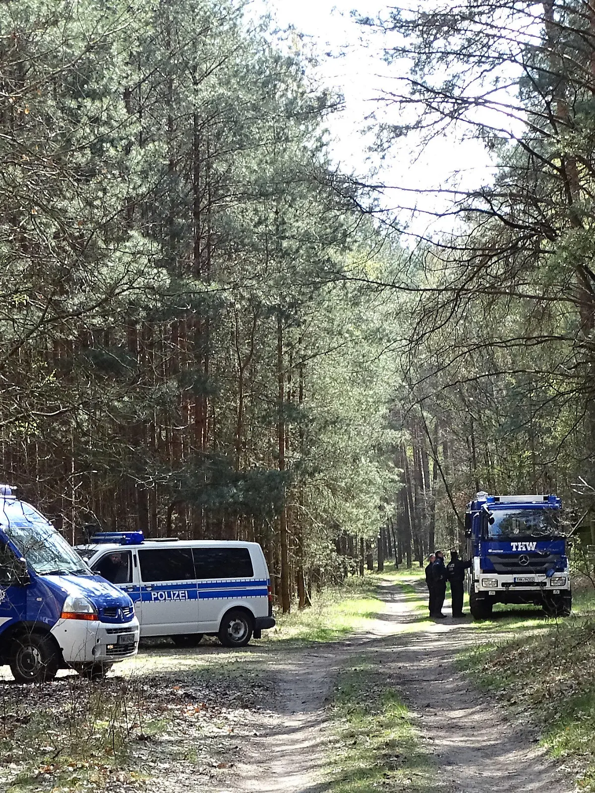 10.04.2019, Brandenburg, Herzberg: Einsatzfahrzeuge des THW und der Polizei stehen in einem Waldgebiet am Herzberger See. Nach mehrtägiger Pause sucht die Berliner Polizei erneut mit Hunden nach der verschwundenen Schülerin Rebecca. Foto: Toni Feist/dpa-Zentralbild/dpa +++ dpa-Bildfunk +++