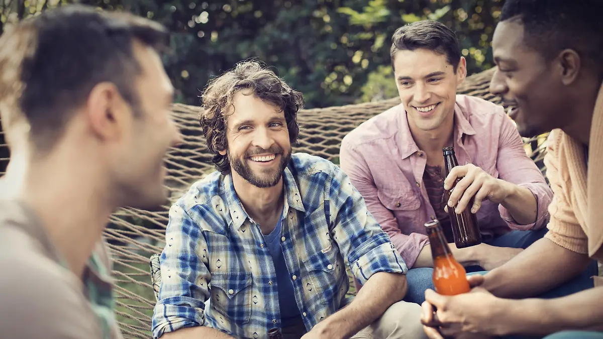 A group of friends lounging in a large hammock in the garden having a beer. A group of friends lounging in a large hammock in the garden having a beer. PUBLICATIONxINxGERxSUIxAUTxHUNxONLY 20618