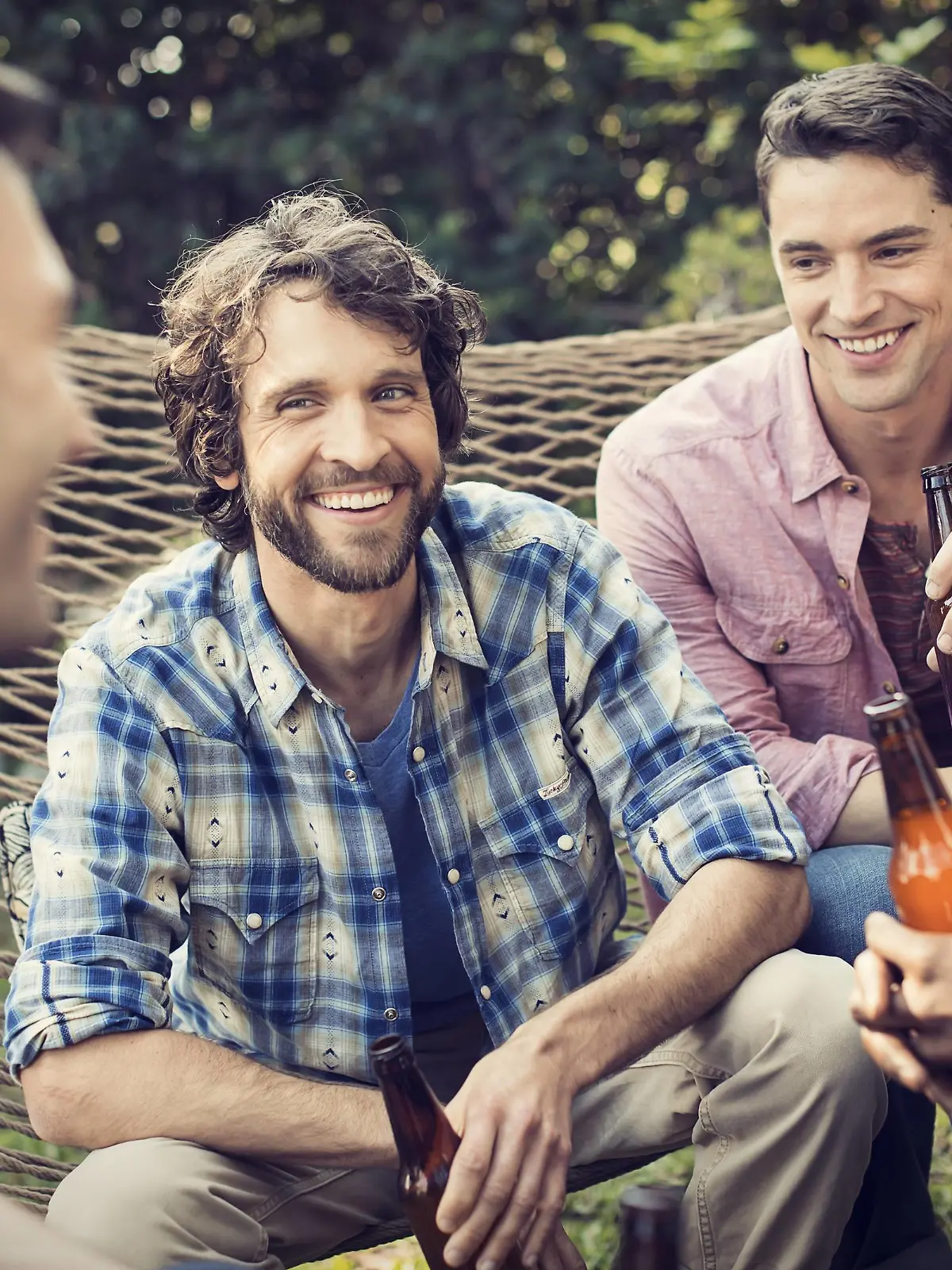 A group of friends lounging in a large hammock in the garden having a beer. A group of friends lounging in a large hammock in the garden having a beer. PUBLICATIONxINxGERxSUIxAUTxHUNxONLY 20618  